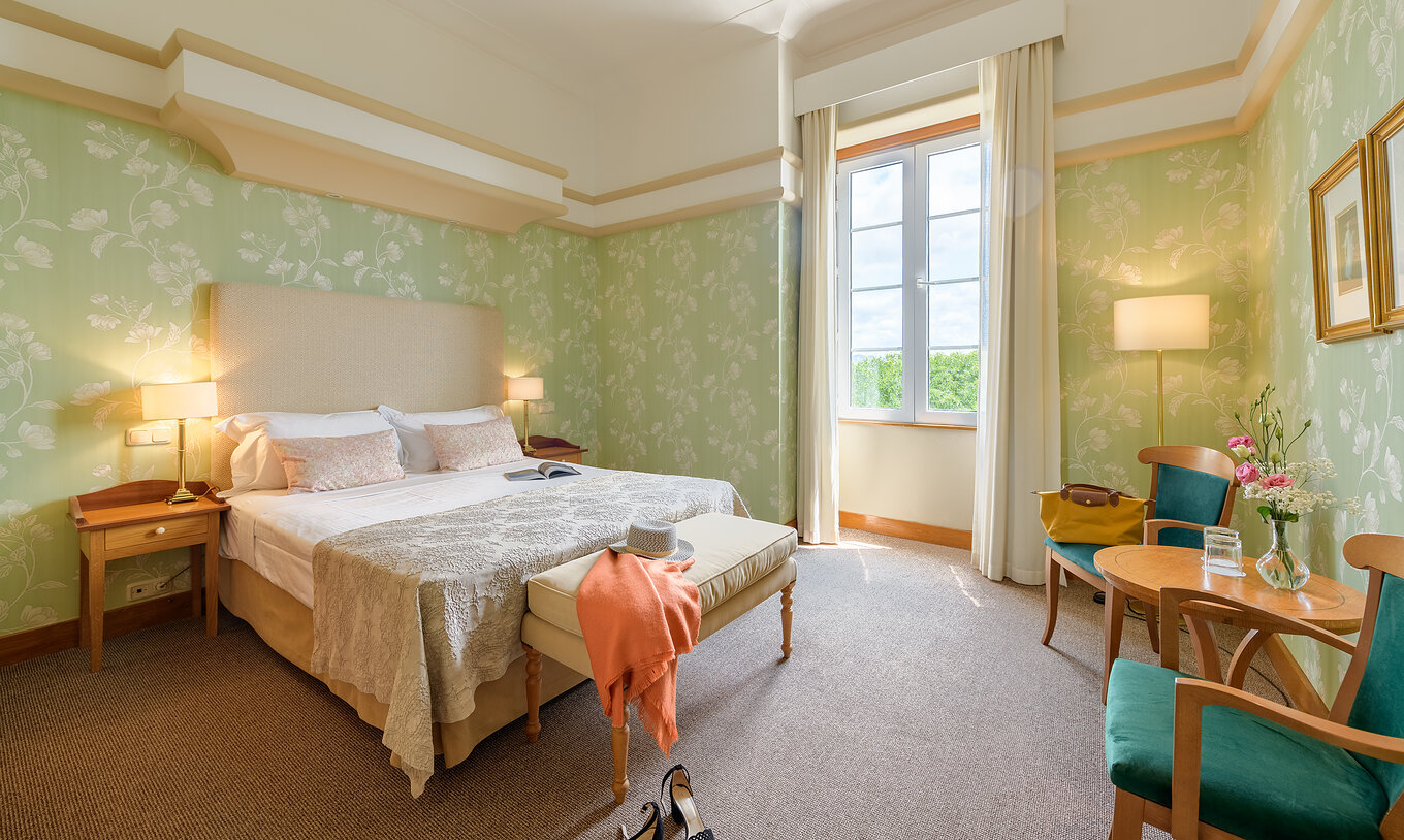 De Klassieke Kamer Pousada Viana do Castelo heeft een raam naast het bed en twee fauteuils