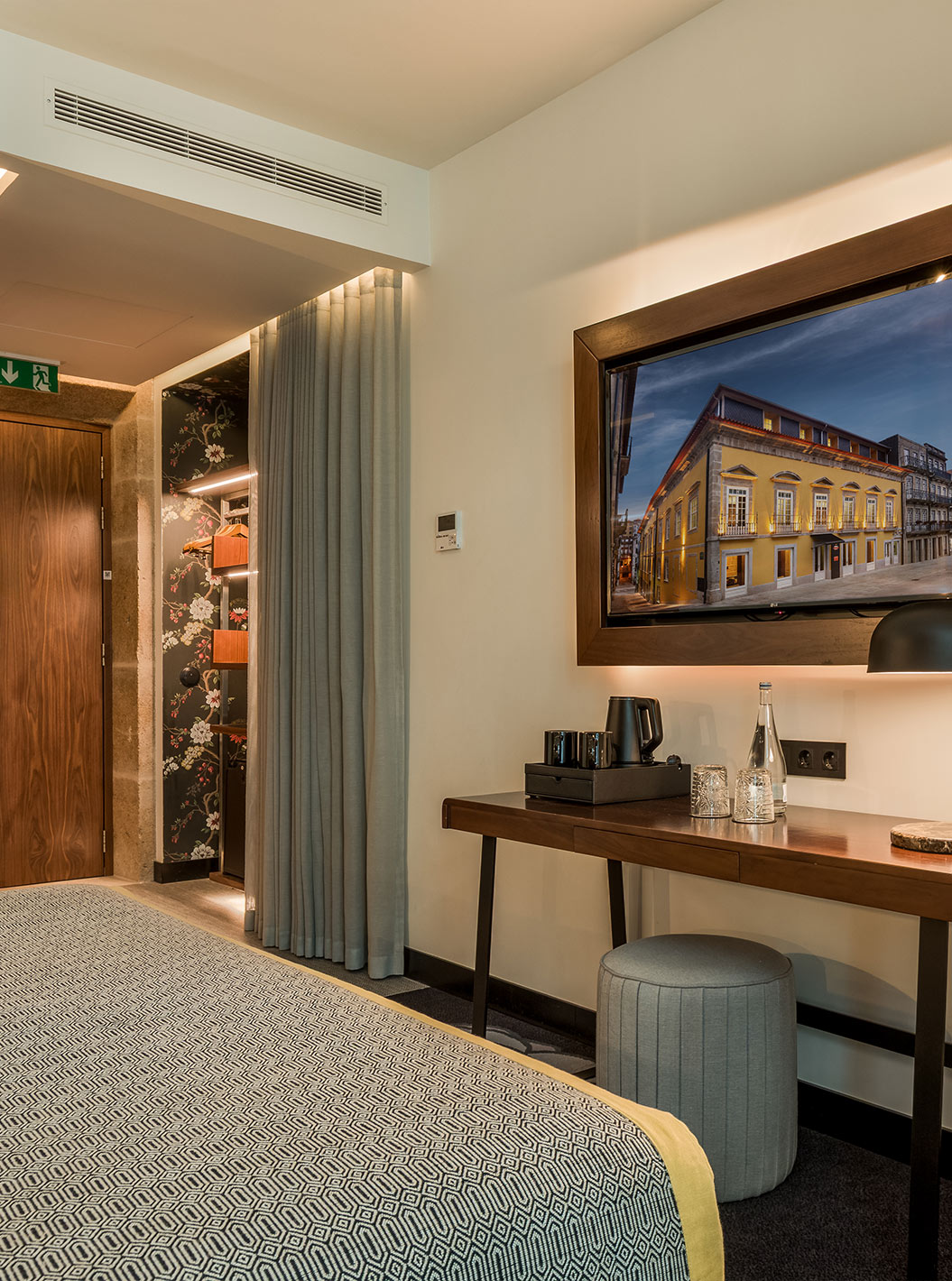 De Deluxe van Pousada Porto - Rua das Flores heeft een bureau en televisie tegenover het bed, een fauteuil en een poef