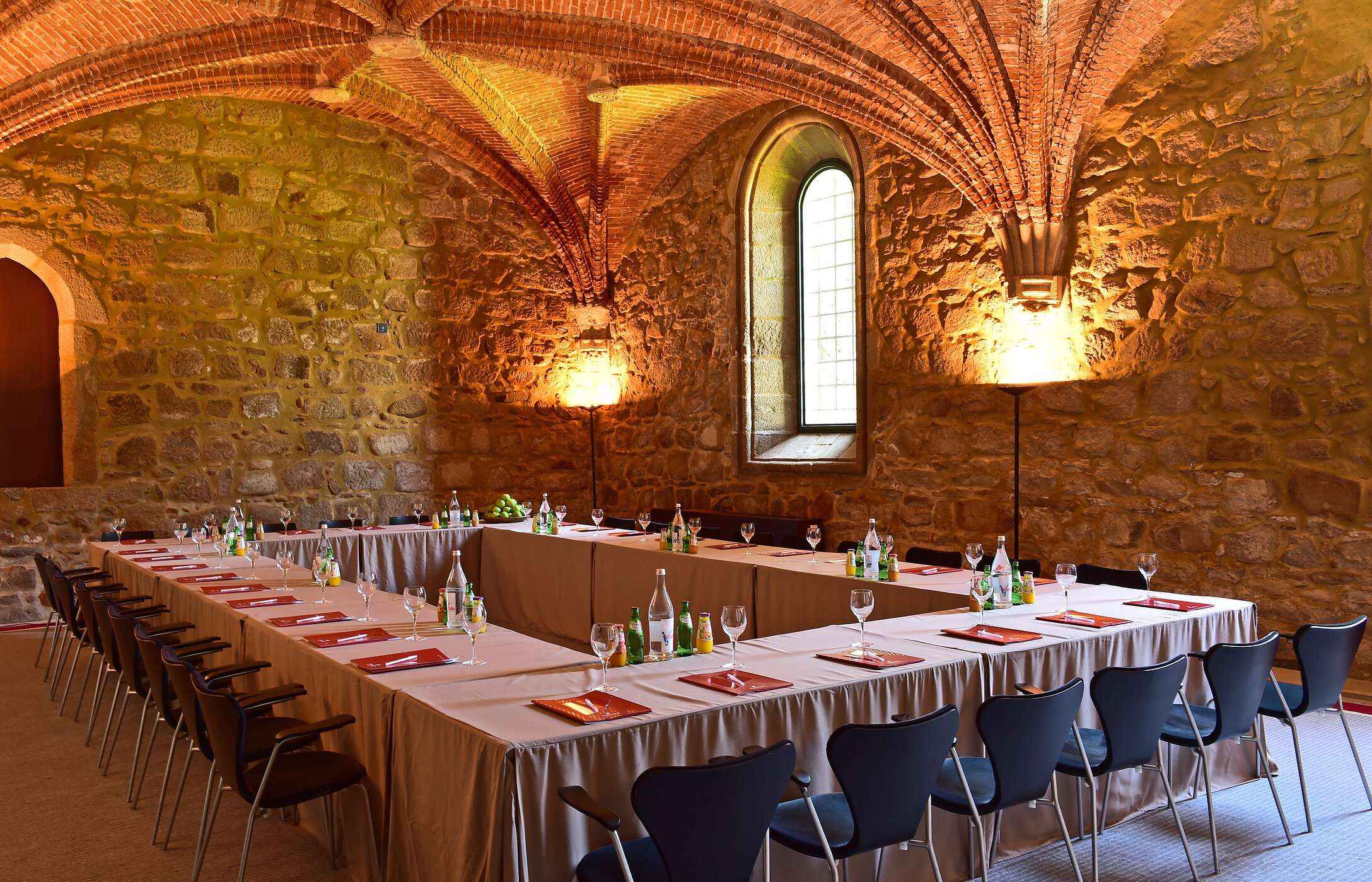 Vergader- of conferentieruimte, met een rustiek en elegant ontwerp, stenen muren, gewelfd plafond en een tafel met dranken