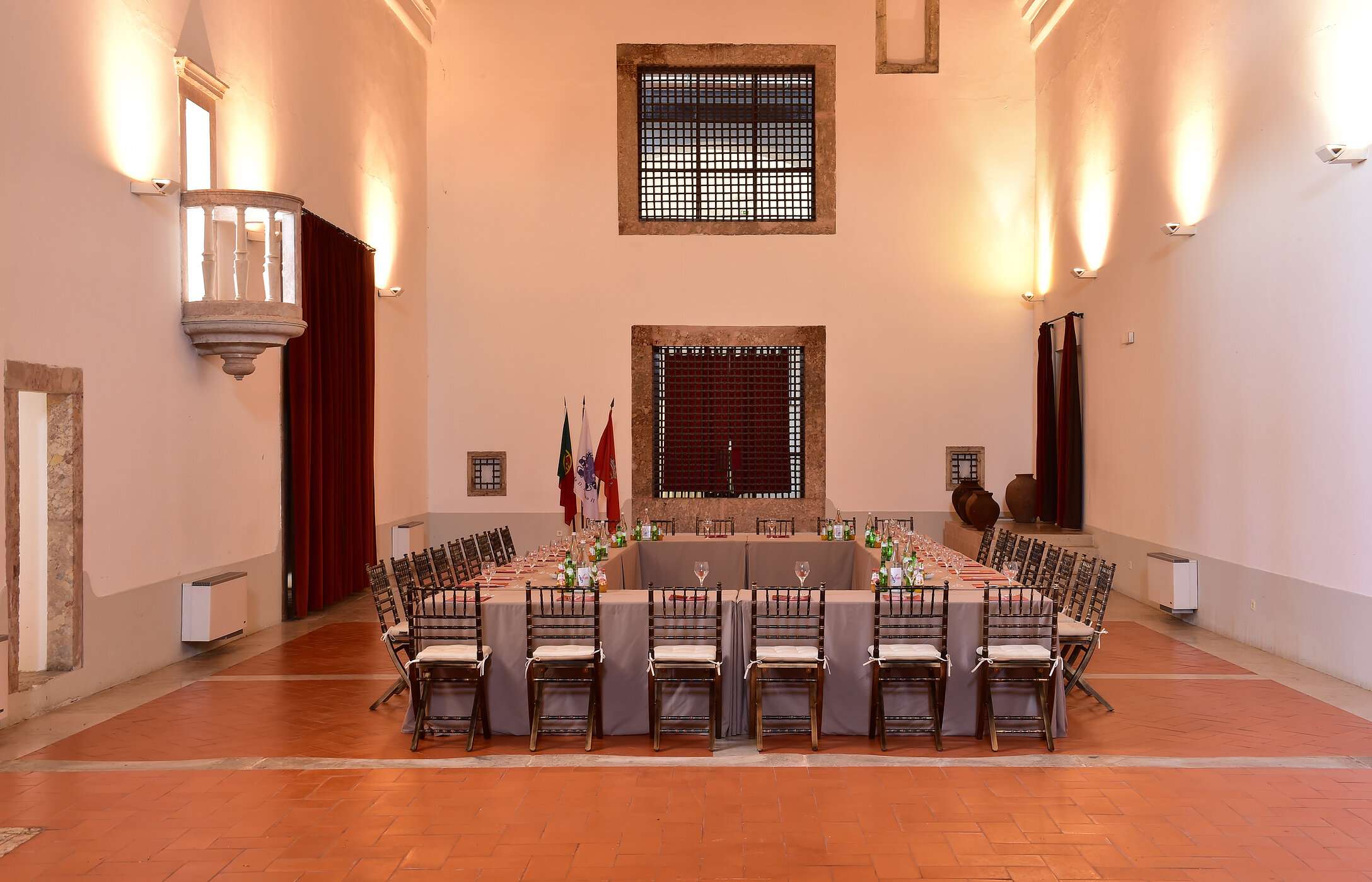 Historische kamer voor vergaderingen of conferenties, met hoge muren en een grote rechthoekige tafel met stoelen en drankjes