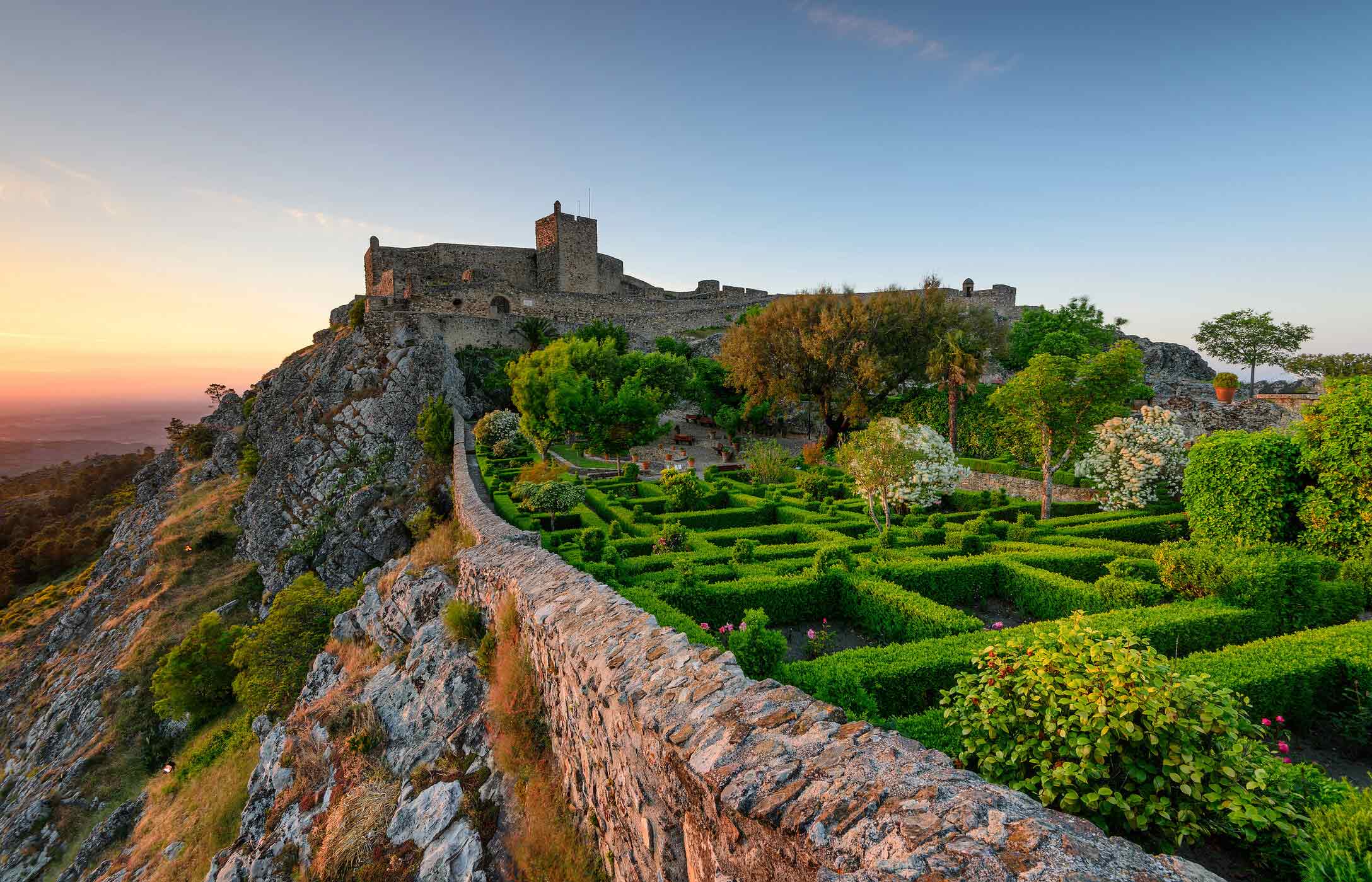 Vista panorâmica do Castelo de Marvão, situado no topo de uma colina, rodeado por jardins e com vista para a planície