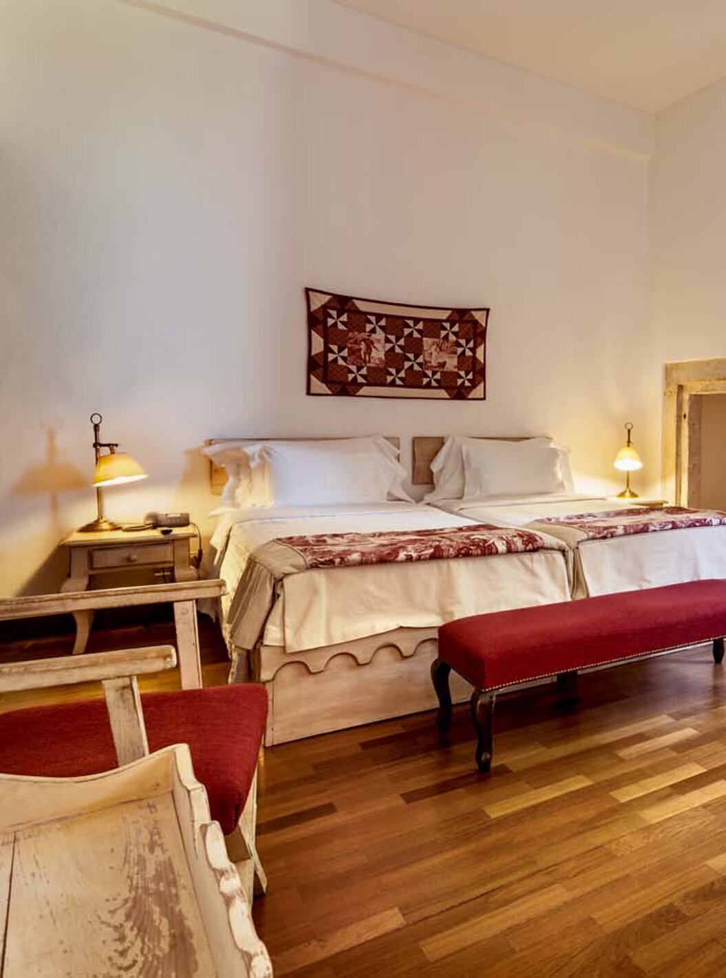 O Quarto Clássico da Pousada Castelo Alvito tem duas camas, duas mesas de cabeceira e um banco ao fundo da cama