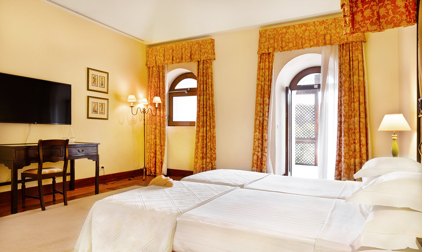 O Quarto Família da Pousada Convento Vila Viçosa tem uma janela e uma porta de acesso a um terraço ao lado da cama