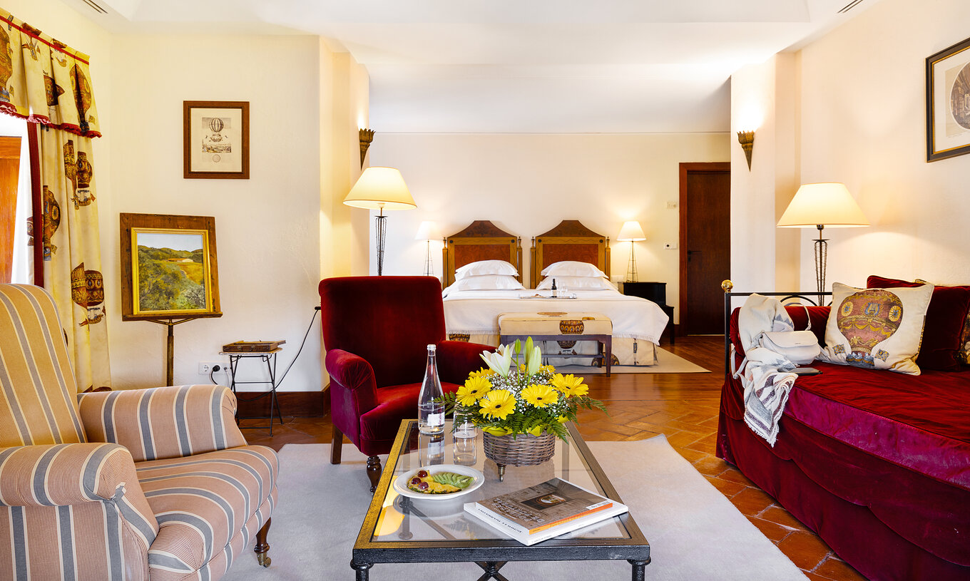 A Suite da Pousada Convento Vila Viçosa tem uma zona de estar com um sofá e dois cadeirões