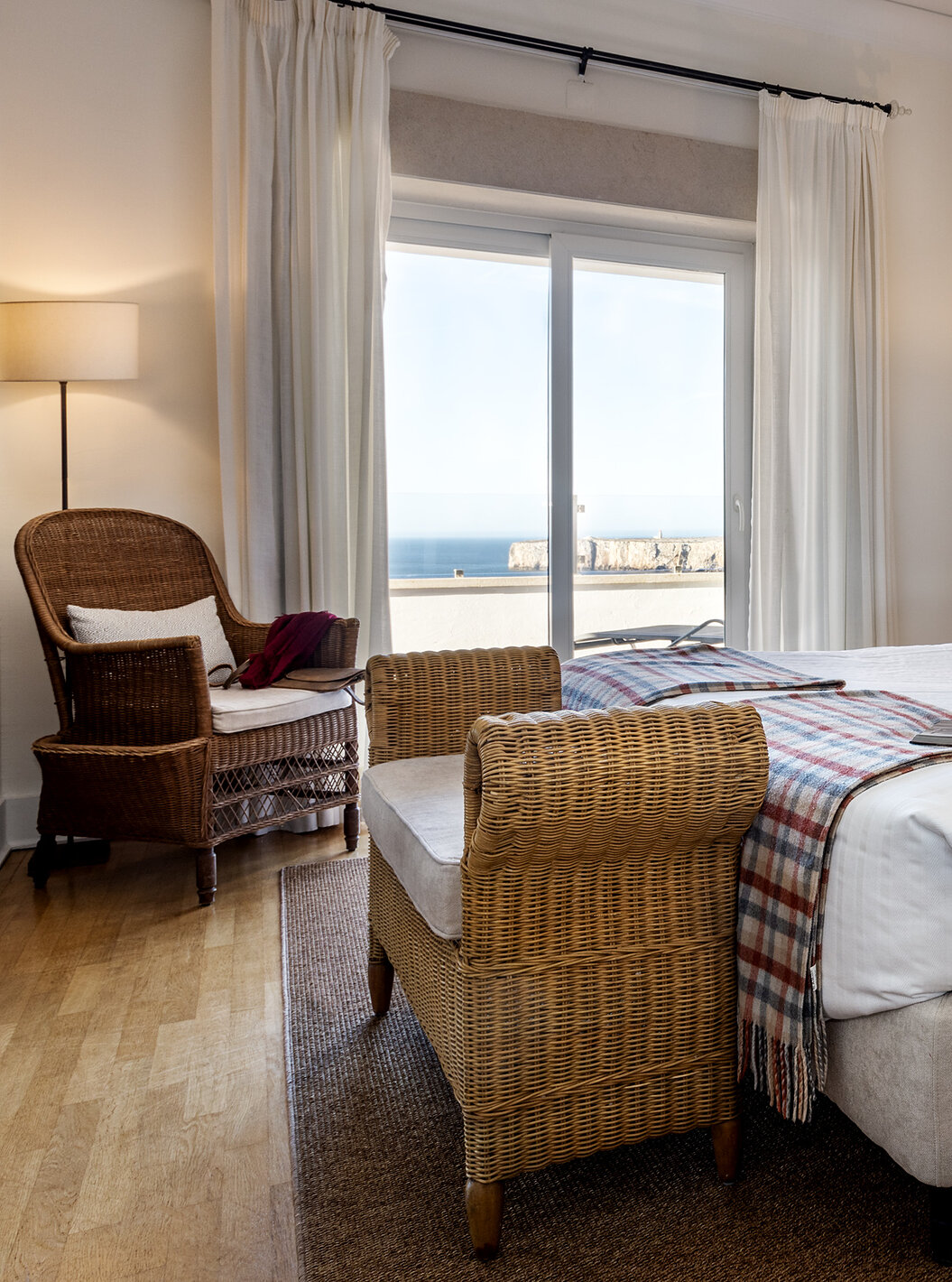 A Master Suite da Pousada Sagres conta com duas camas com cabeceira às riscas, dois espelhos redondos e uma varanda