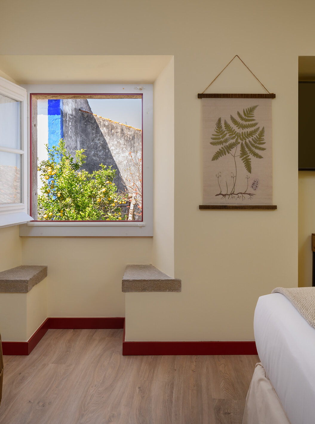 A Suite da Casa Lidador - Óbidos tem uma televisão, uma secretária e uma janela quadrada com dois bancos em pedra