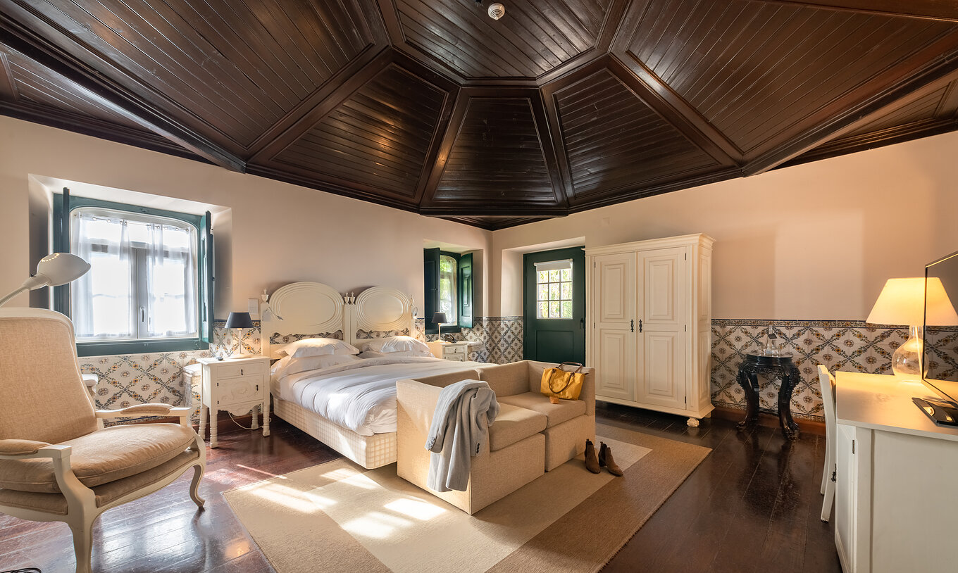 O quarto Superior com Varanda Casa do Castelo da Pousada Castelo Óbidos tem uma cama, sofá e candeeiro