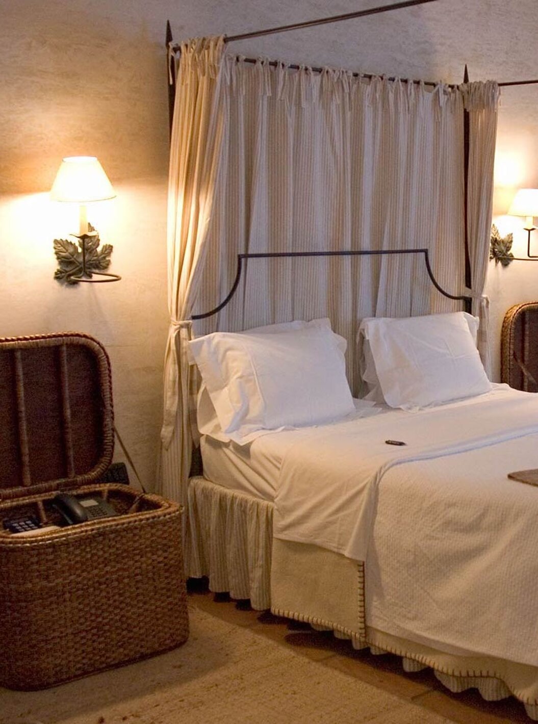 O Quarto Clássico da Pousada Convento de Belmonte tem uma cama de casal e duas mesas de cabeceira em cestos de vime