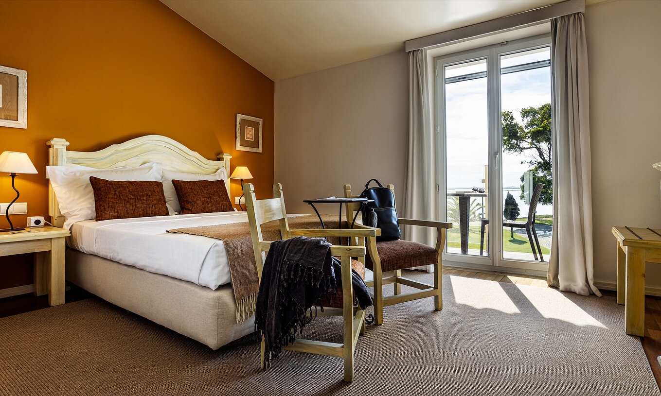 O Quarto Large Family da Pousada Ria - Aveiro conta com uma cama de casal, duas cadeiras e uma varanda com vista para a ria