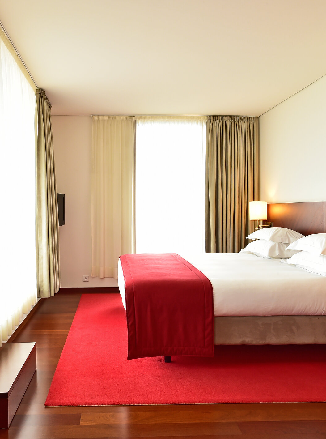 A Suite Especial da Pousada Viseu tem uma cama de casal, um candeeiro e duas janelas grandes com cortinas