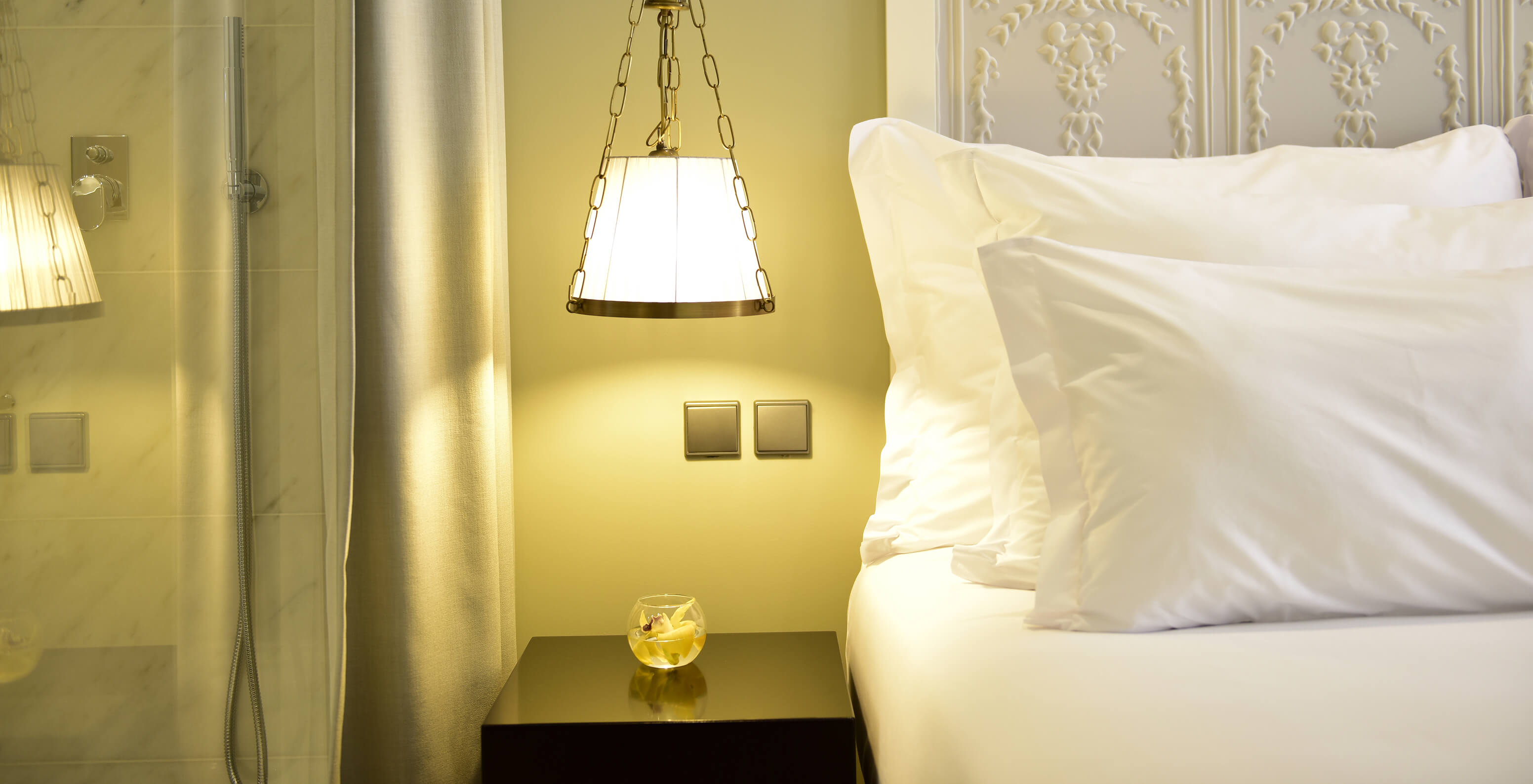 O Cozy Queen Size Bed da Pousada Lisboa Praça do Comércio tem uma cama com a cabeceira decorada e um candeeiro suspenso