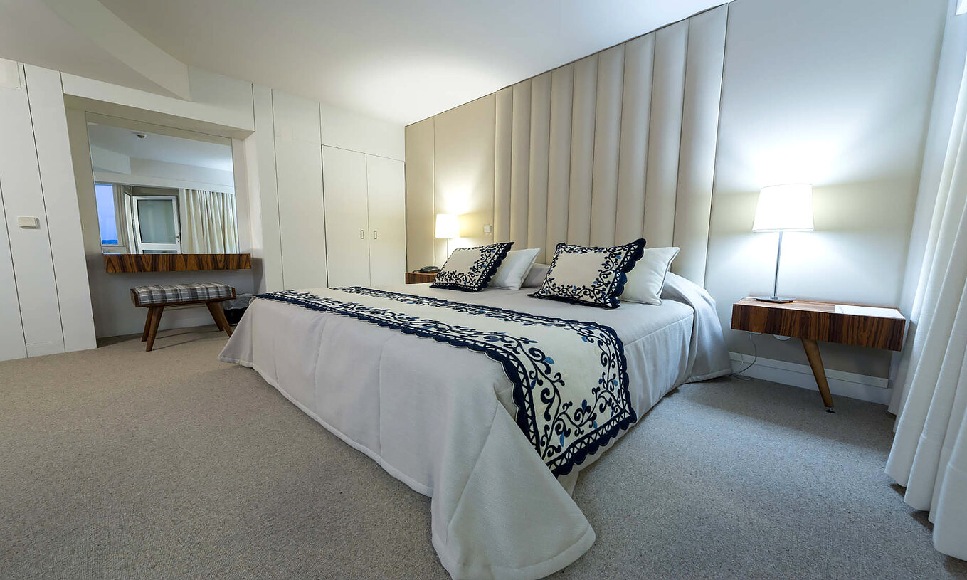 O Quarto Clássico da Pousada Bragança tem uma cama de casal, mesa de cabeceira com candeeiro, e um armário embutido