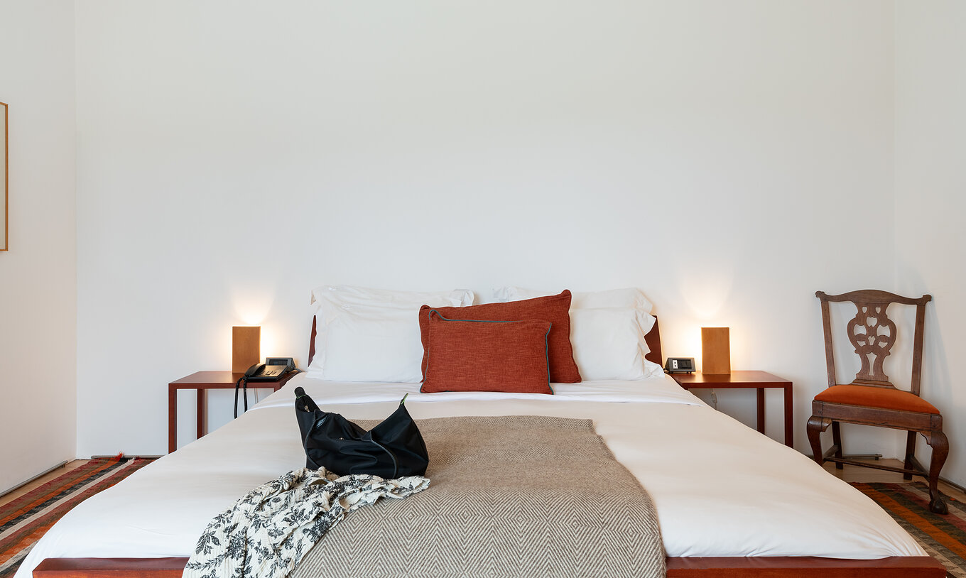 A Suite Standard da Pousada Mosteiro Amares tem uma cama de casal, com duas mesas de cabeceira e uma cadeira