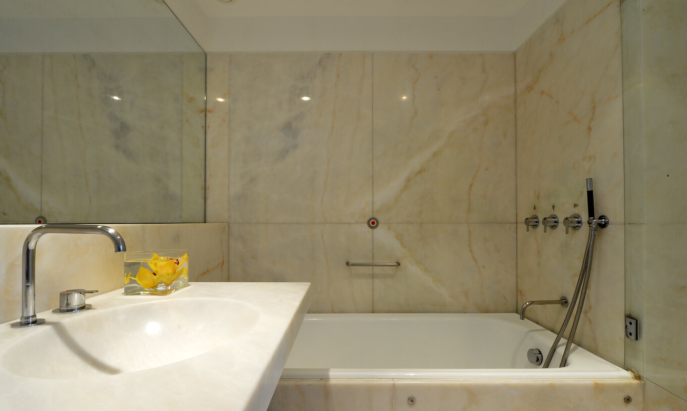 O Quarto Superior da Pousada Mosteiro Amares tem uma casa de banho em mármore com banheira e lavatório