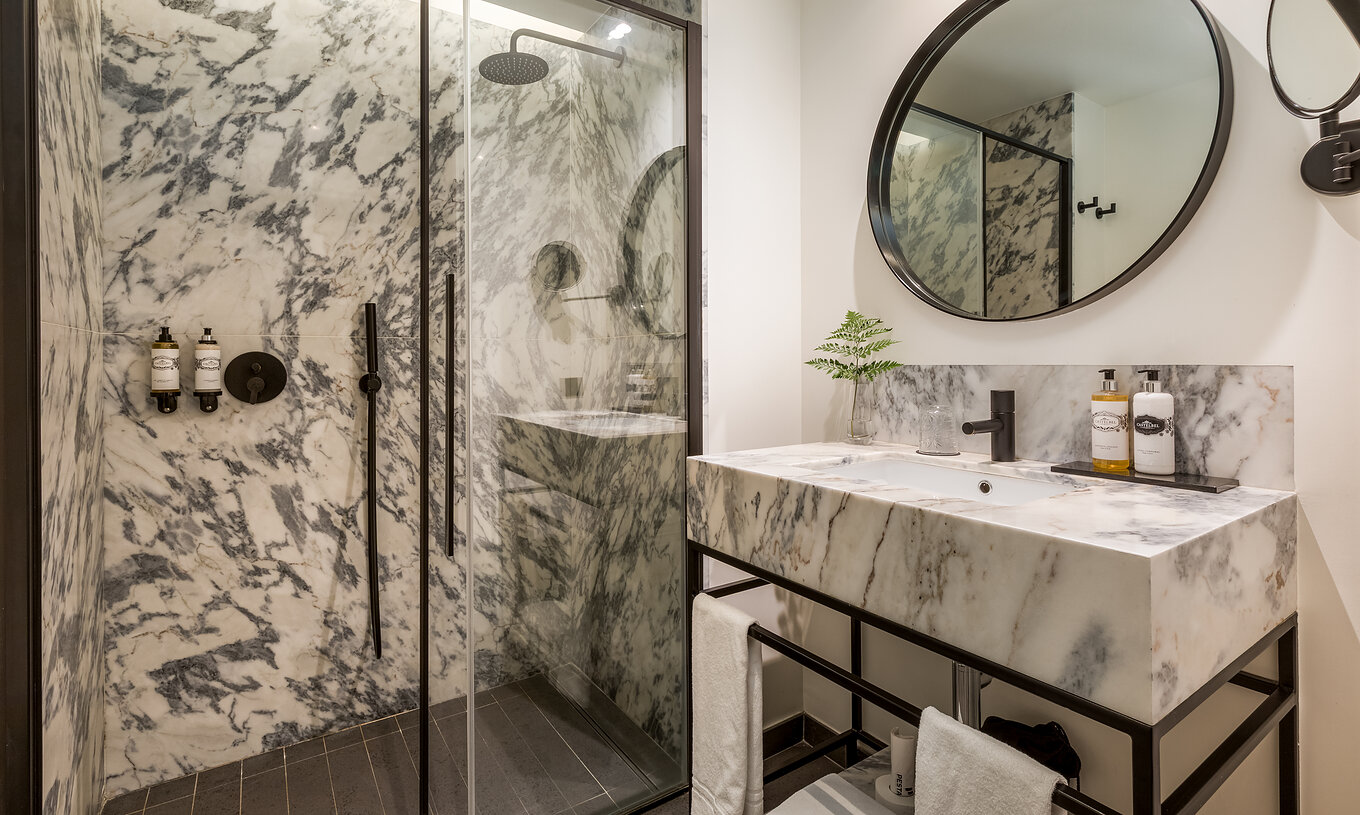 O Cozy Room da Pousada Porto - Rua das Flores tem um chuveiro e um lavatório em mármore preto e branco