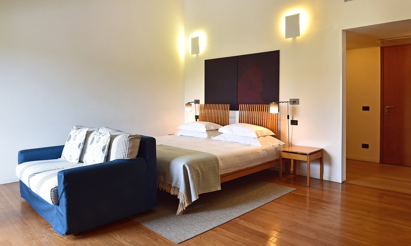 A Junior Suite da Pousada Convento Arraiolos tem duas camas individuais juntas e um sofá-cama em tons de azul e branco