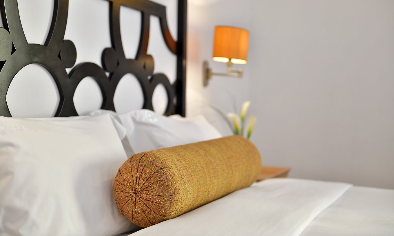 O Duplo da Pousada Marvão conta com uma cama com uma almofada em forma de rolo amarela