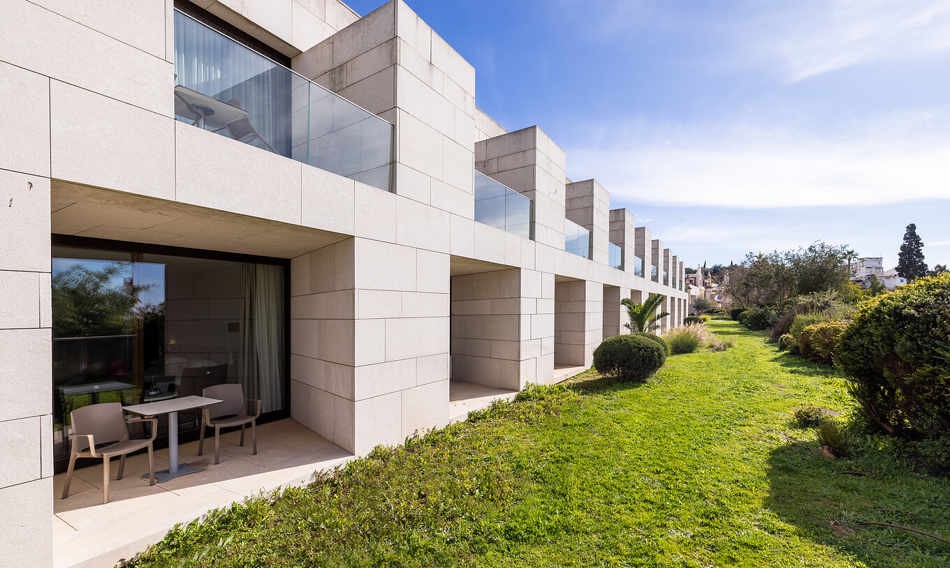 O Quarto Clássico da Pousada Palácio Estoi onde existe várias varandas abertas com um espaço bastante agradável