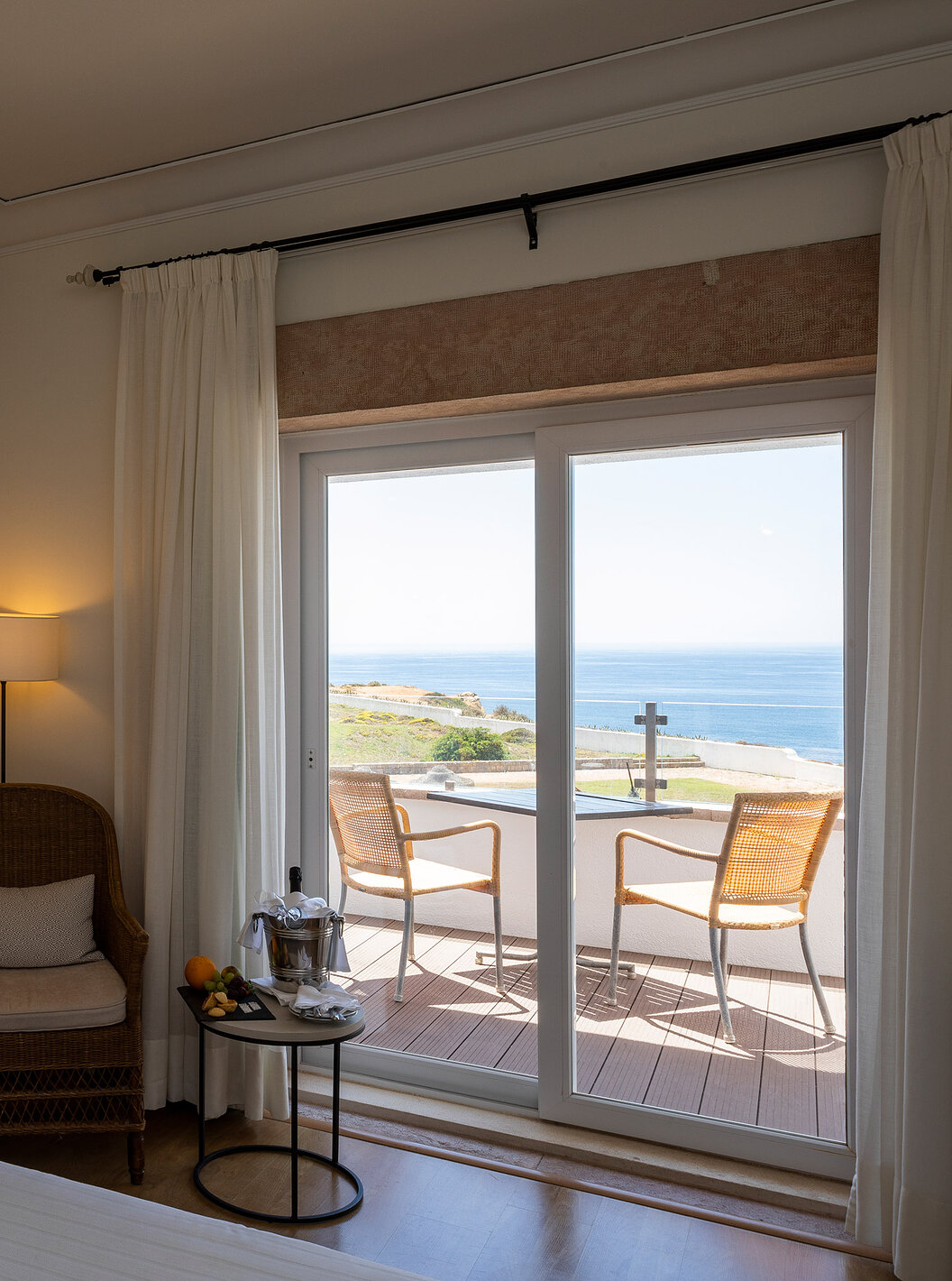 O Quarto Superior da Pousada Sagres conta com uma varanda com mesa e cadeiras, uma cama com cabeceira às riscas e snacks