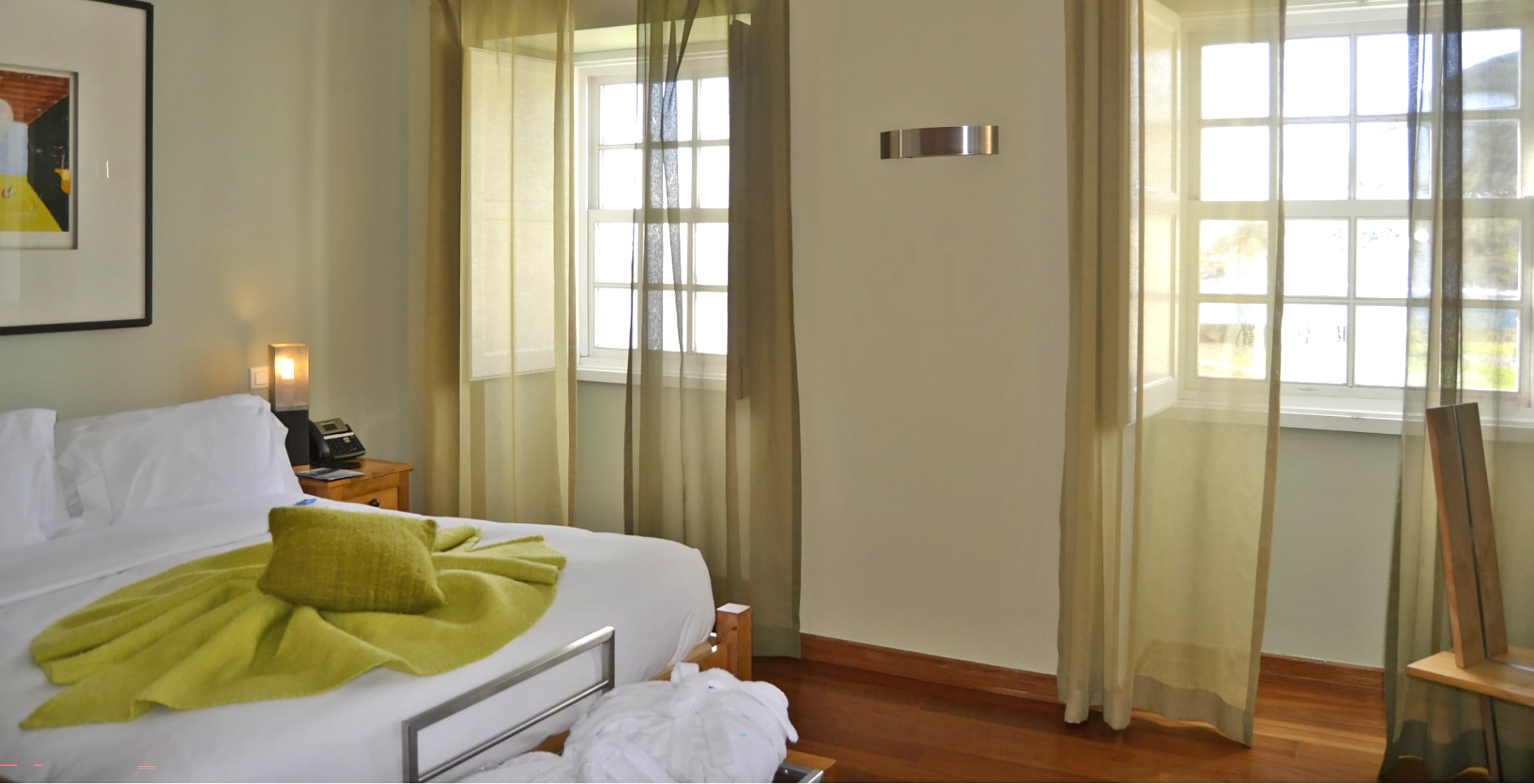 A Suite Standard da Pousada Forte Angra do Heroísmo tem duas janelas ao lado da cama com vista para o mar