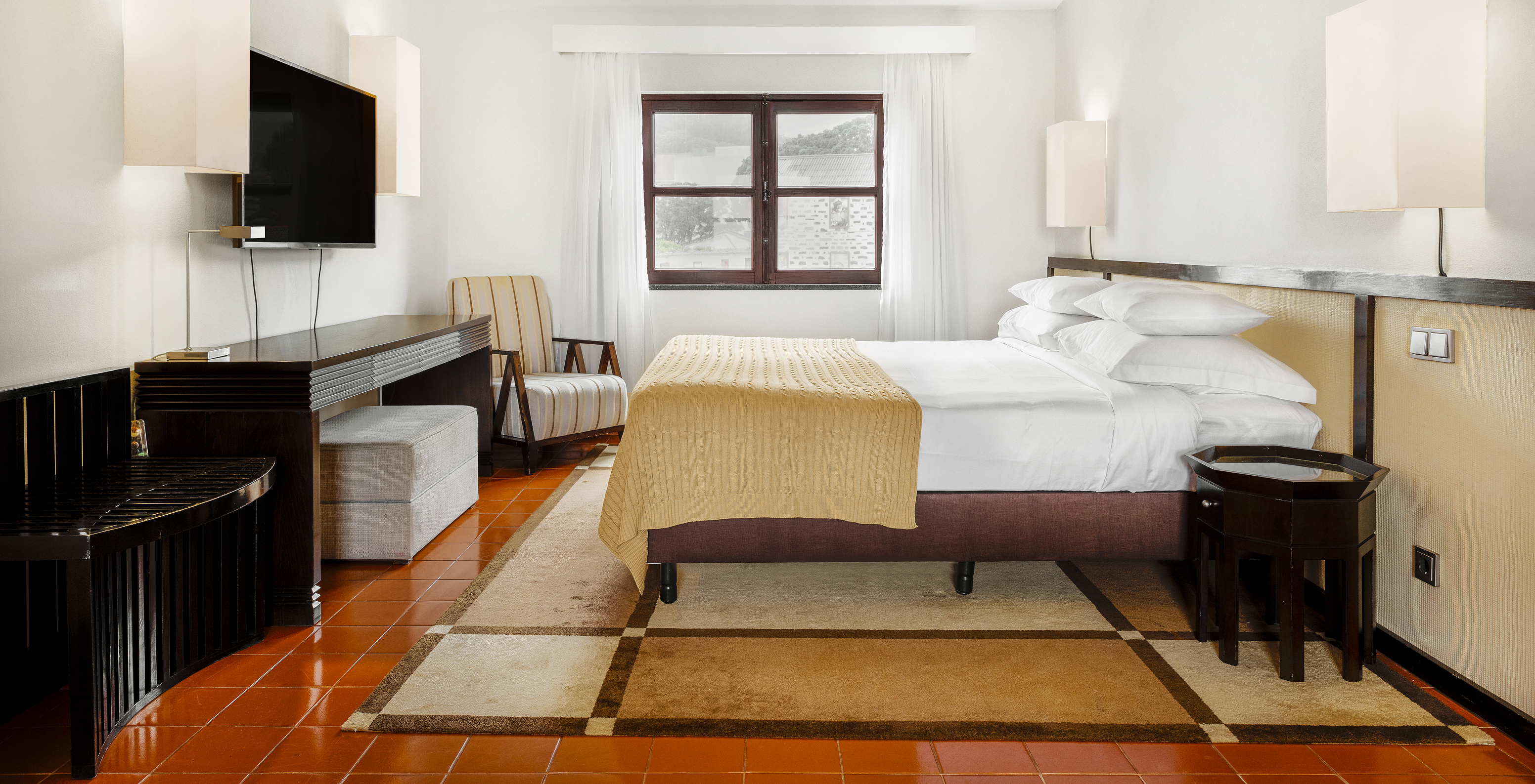 O quarto Master Suite da Pousada Forte Horta tem uma cama de casal e uma televisão em frente à cama