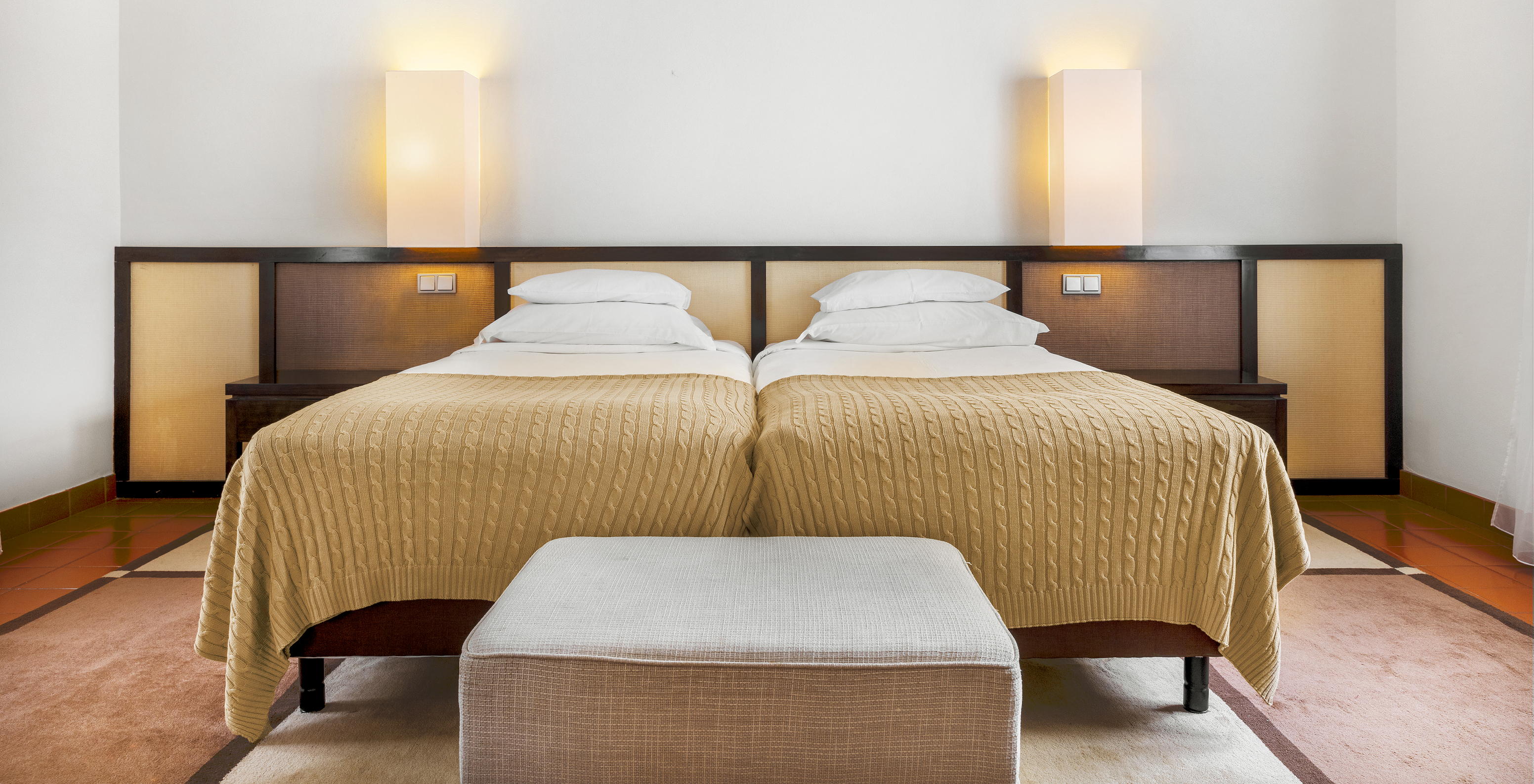 A Suite Standard da Pousada Forte Horta tem duas camas individuais, com mesa de cabeceira com candeeiro