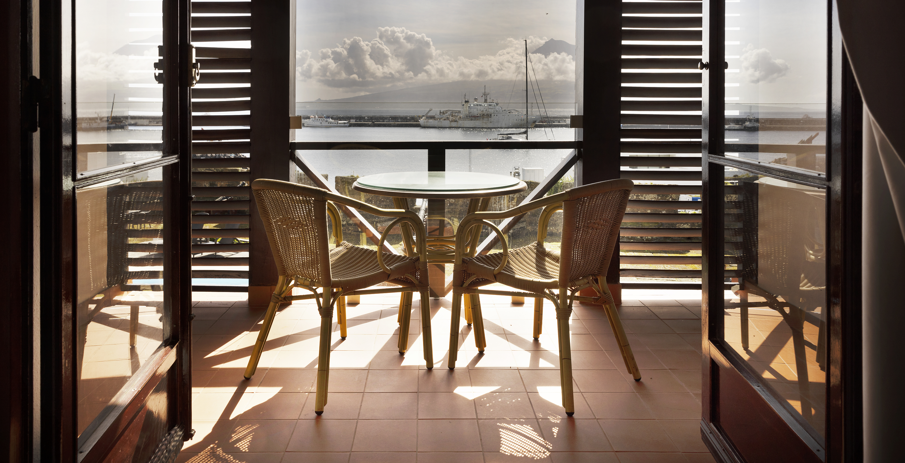O quarto Superior Família da Pousada Forte Horta tem uma varanda com mesa e cadeiras, vista para o mar