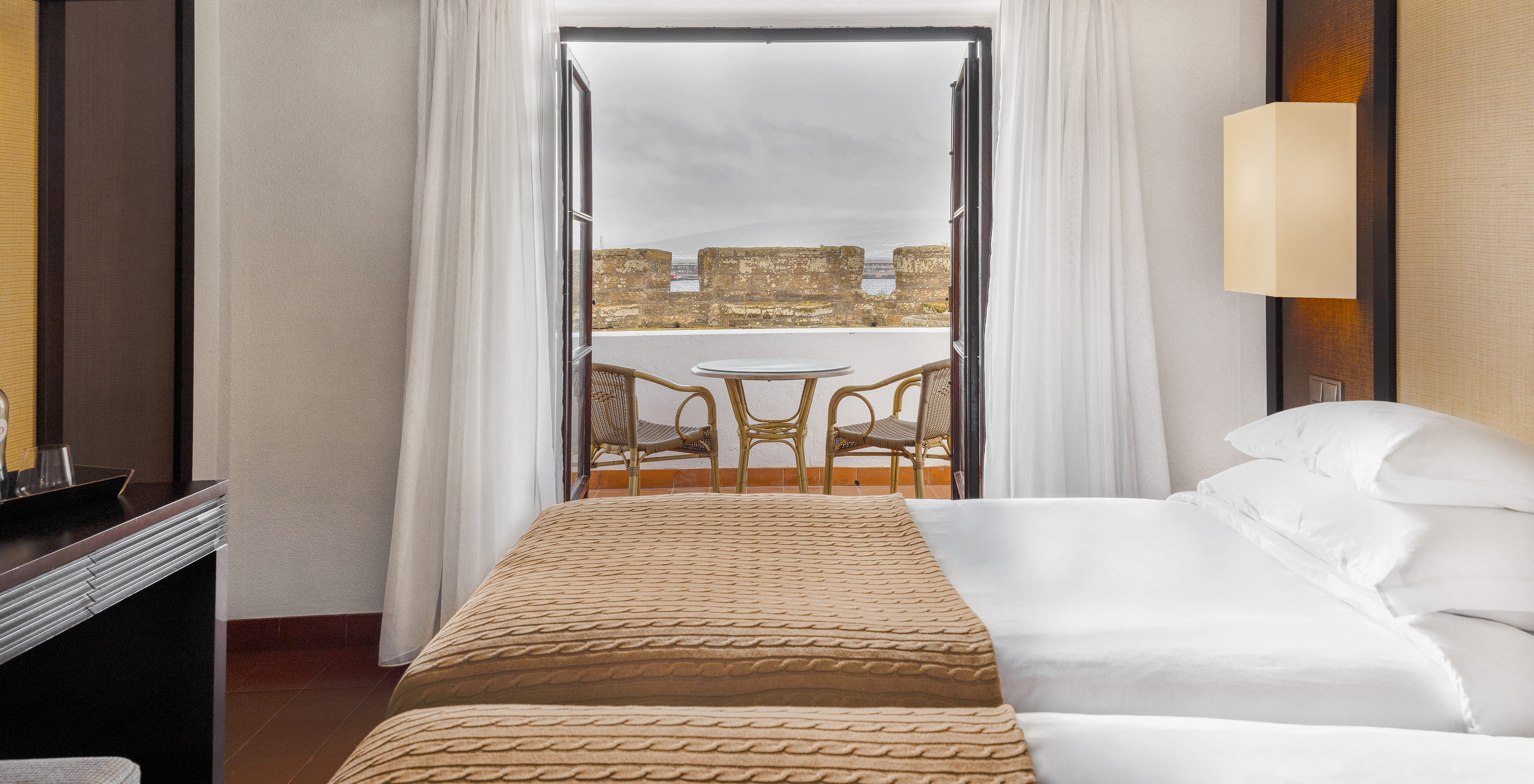 O Quarto Superior da Pousada Forte Horta tem uma varanda com mesa e cadeiras, e vista para o forte