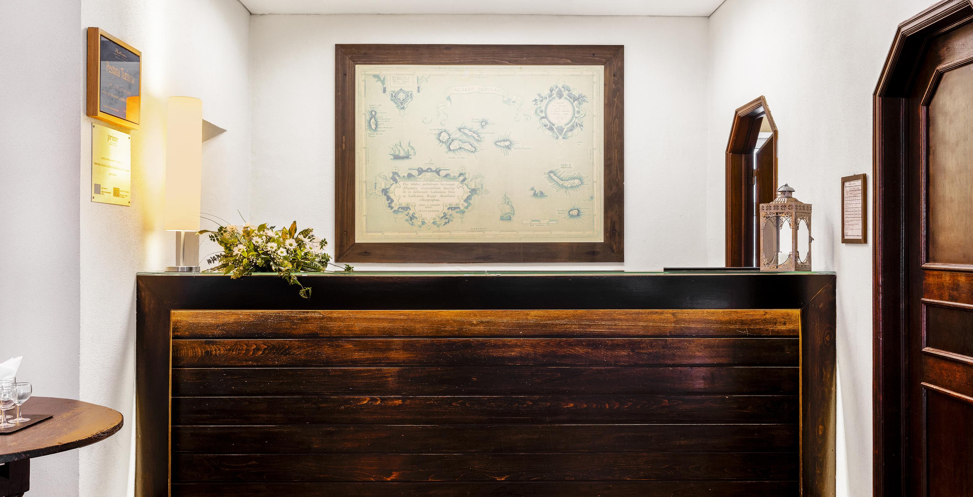 A Pousada Forte da Horta, hotel histórico nos Açores, tem uma receção em madeira com um quadro no fundo da parede