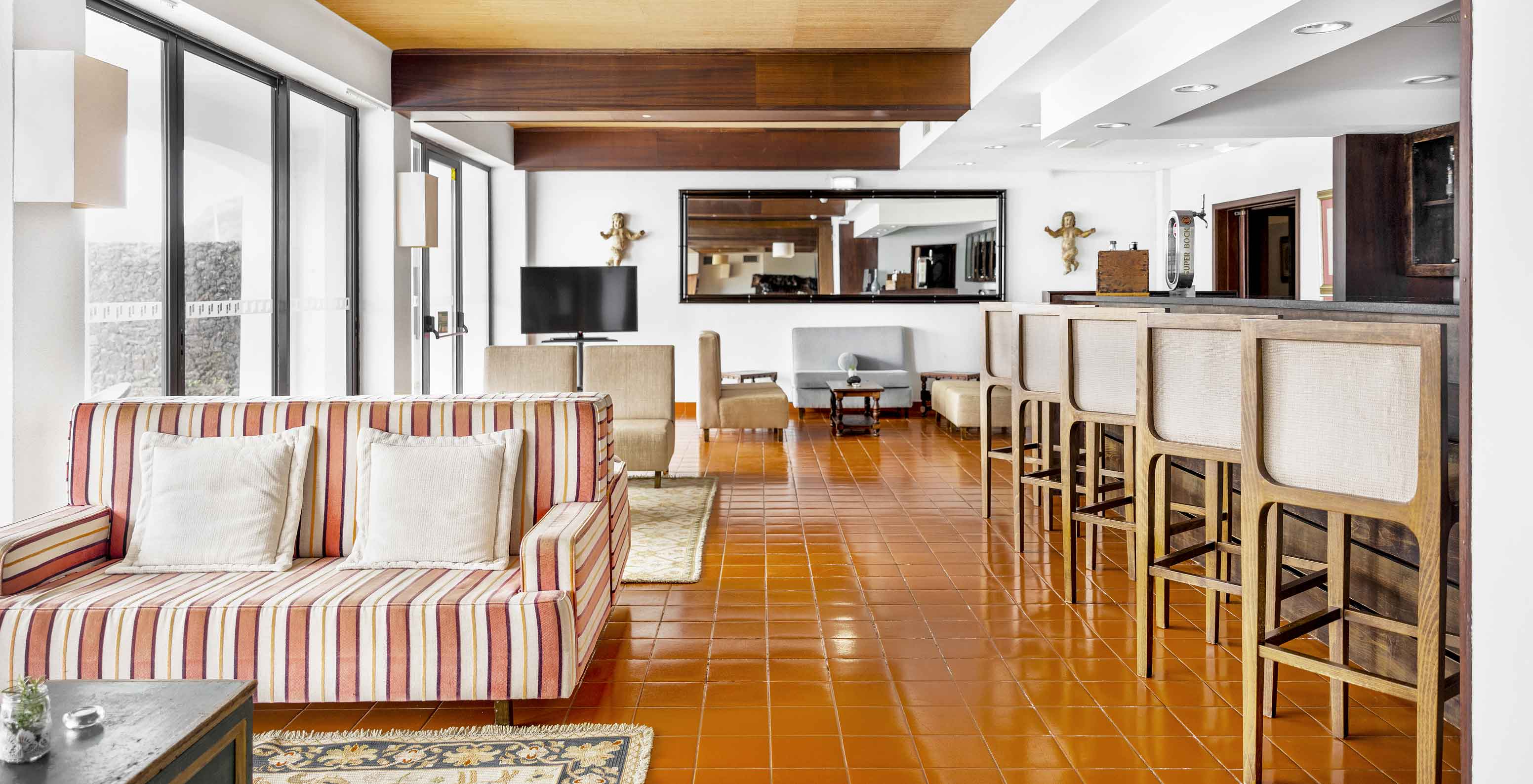 O bar do Hotel Histórico na Horta, Faial tem um sofá e várias cadeiras altas onde pode desfrutar de uma bebida