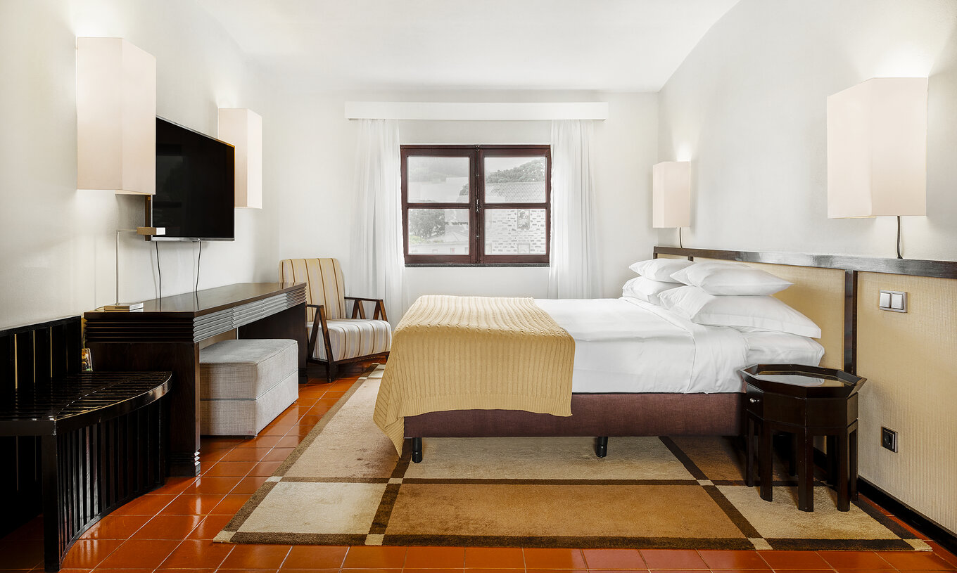 O quarto Master Suite da Pousada Forte Horta tem uma cama de casal e uma televisão em frente à cama