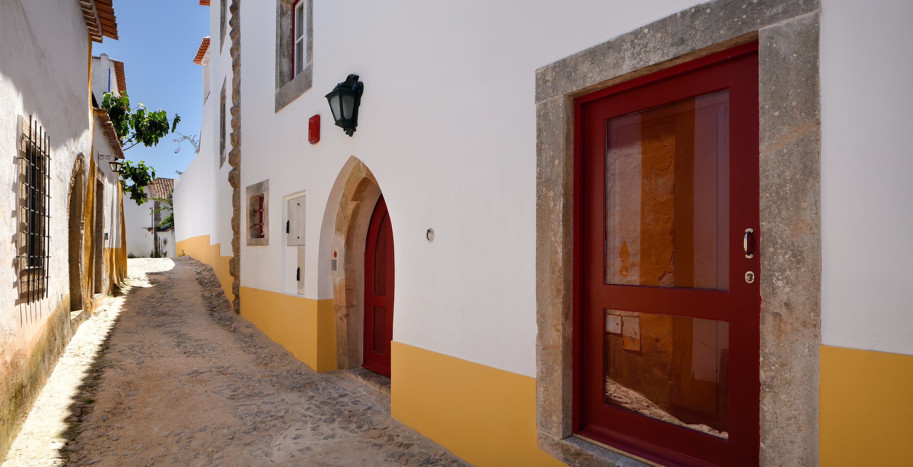 Casas da típica Vila de Óbidos, com ruas estreitas de pedra e fachada branca, com portas de madeira