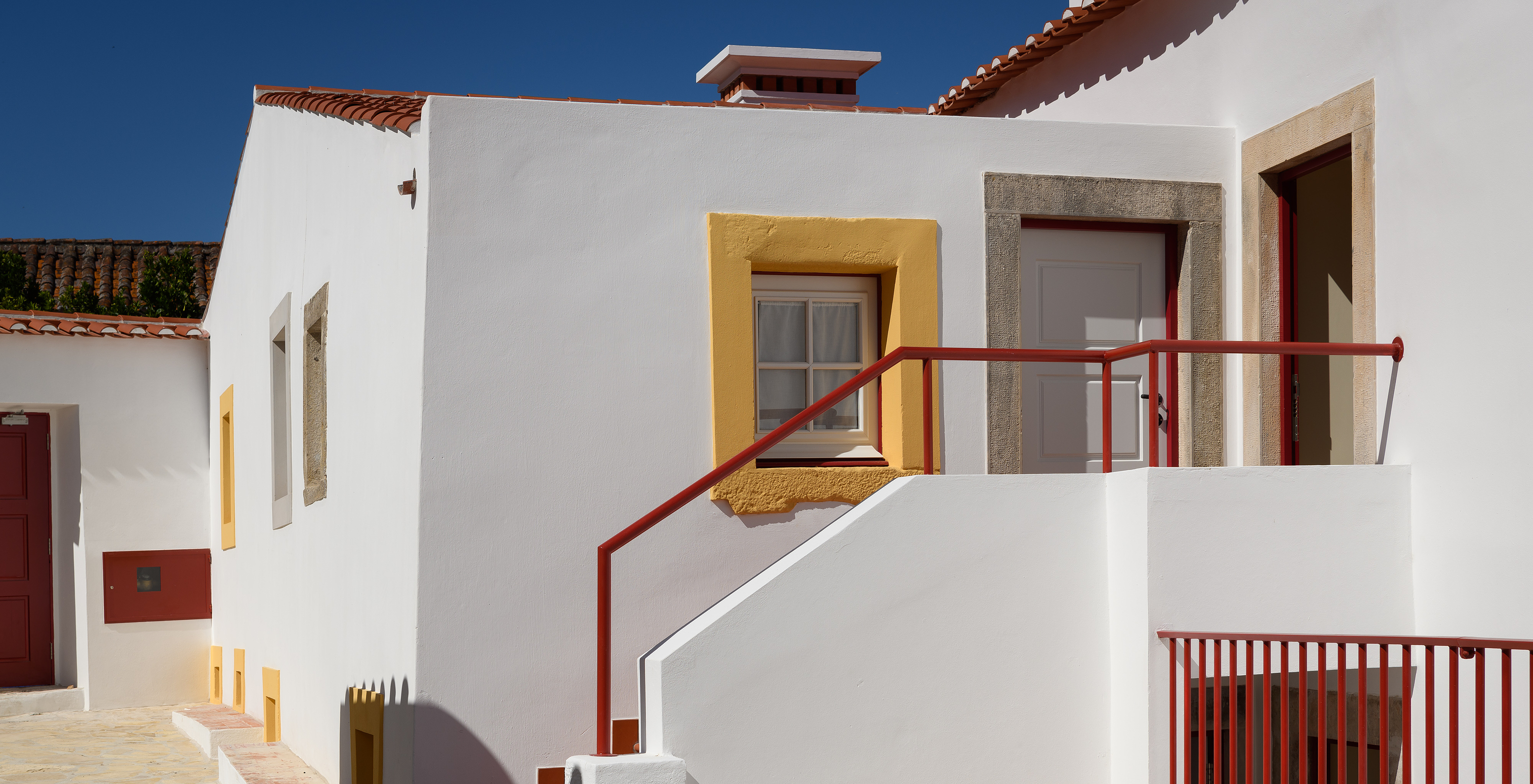 Casa da típica Vila de Óbidos, com a fachada branca e portas e janelas em madeira