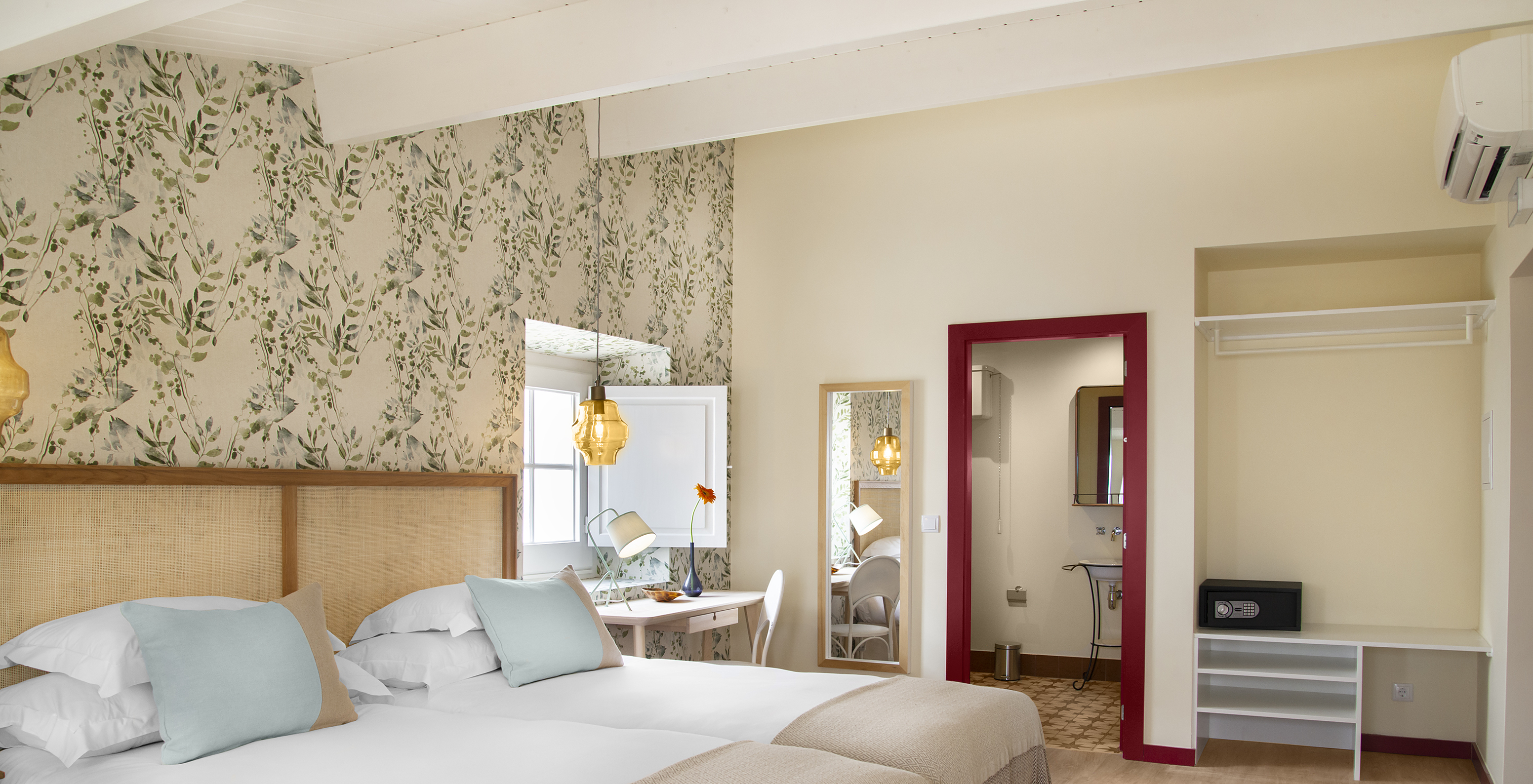 O Quarto Familiar da Casa Lidador - Óbidos tem duas camas individuais, papel de parede florido, janela e espelho na parede