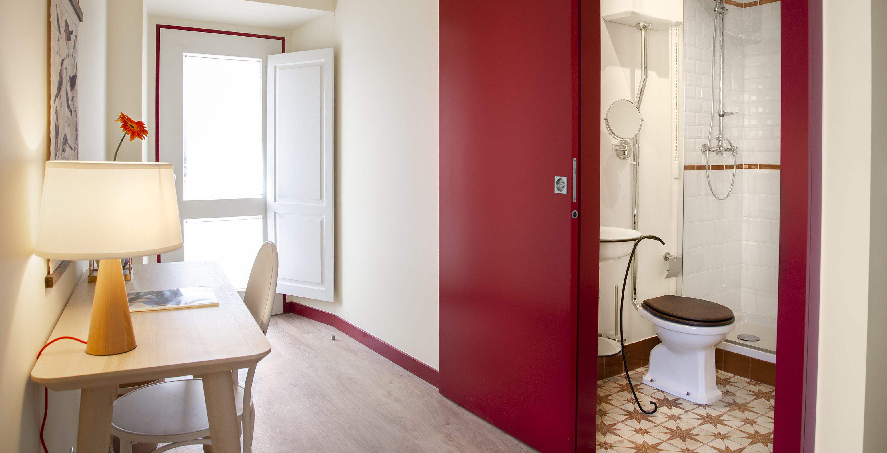O Quarto Superior da Casa Lidador - Óbidos tem uma casa de banho com porta de correr vermelha, lavatório, sanita e duche