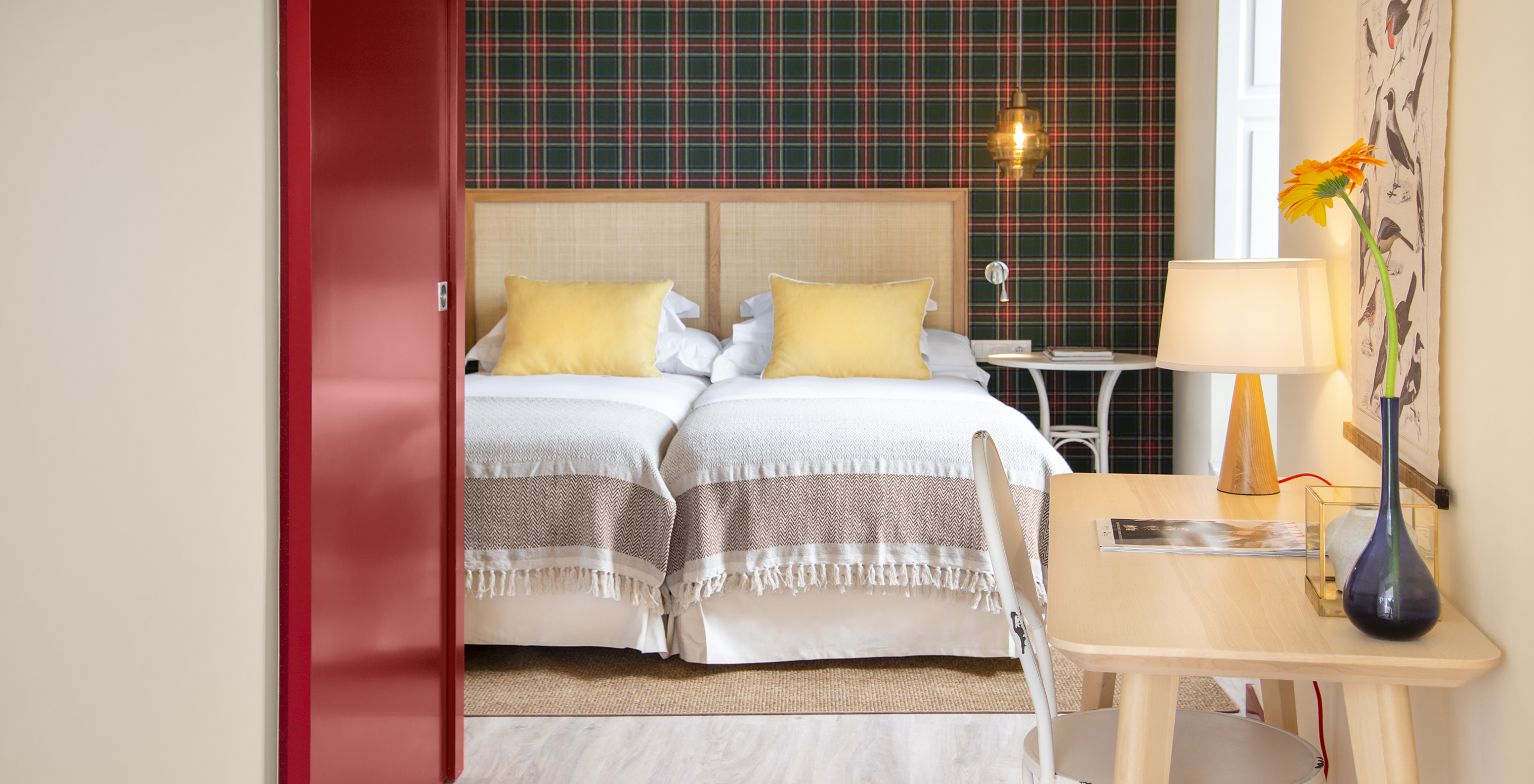 O Quarto Superior da Casa Lidador - Óbidos tem duas camas individuais, papel de parede aos quadrados, janela e uma secretária