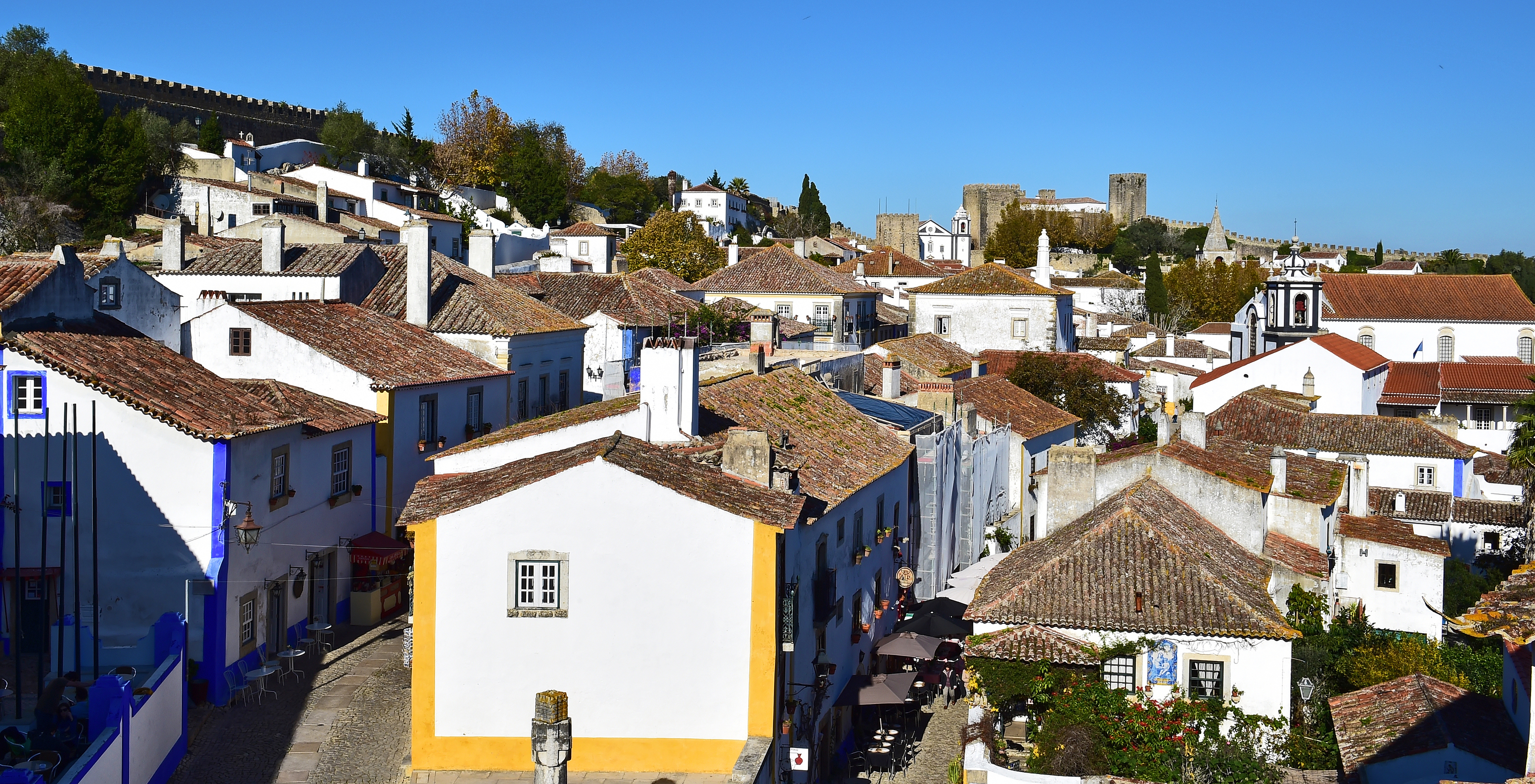 Vila de Óbidos, com ruas de pedra, casas caiadas de branco e flores coloridas