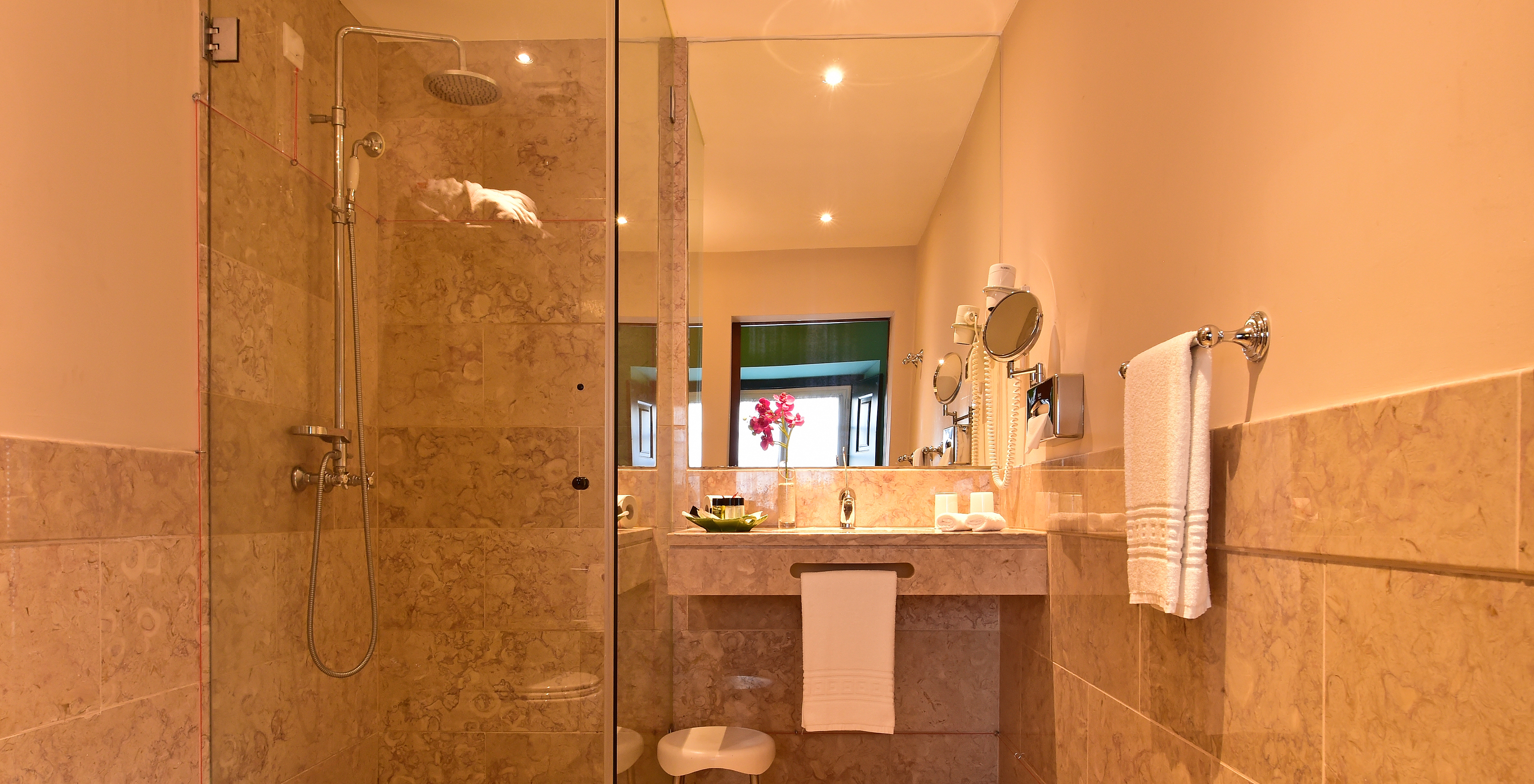 O quarto Large Family Casa do Castelo da Pousada Castelo Óbidos tem uma casa de banho com duche, lavatório, e um espelho 