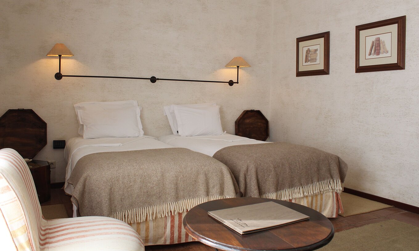 O Quarto Twin com Varanda da Pousada Convento de Belmonte tem duas camas individuais juntas com uma decoração rústica