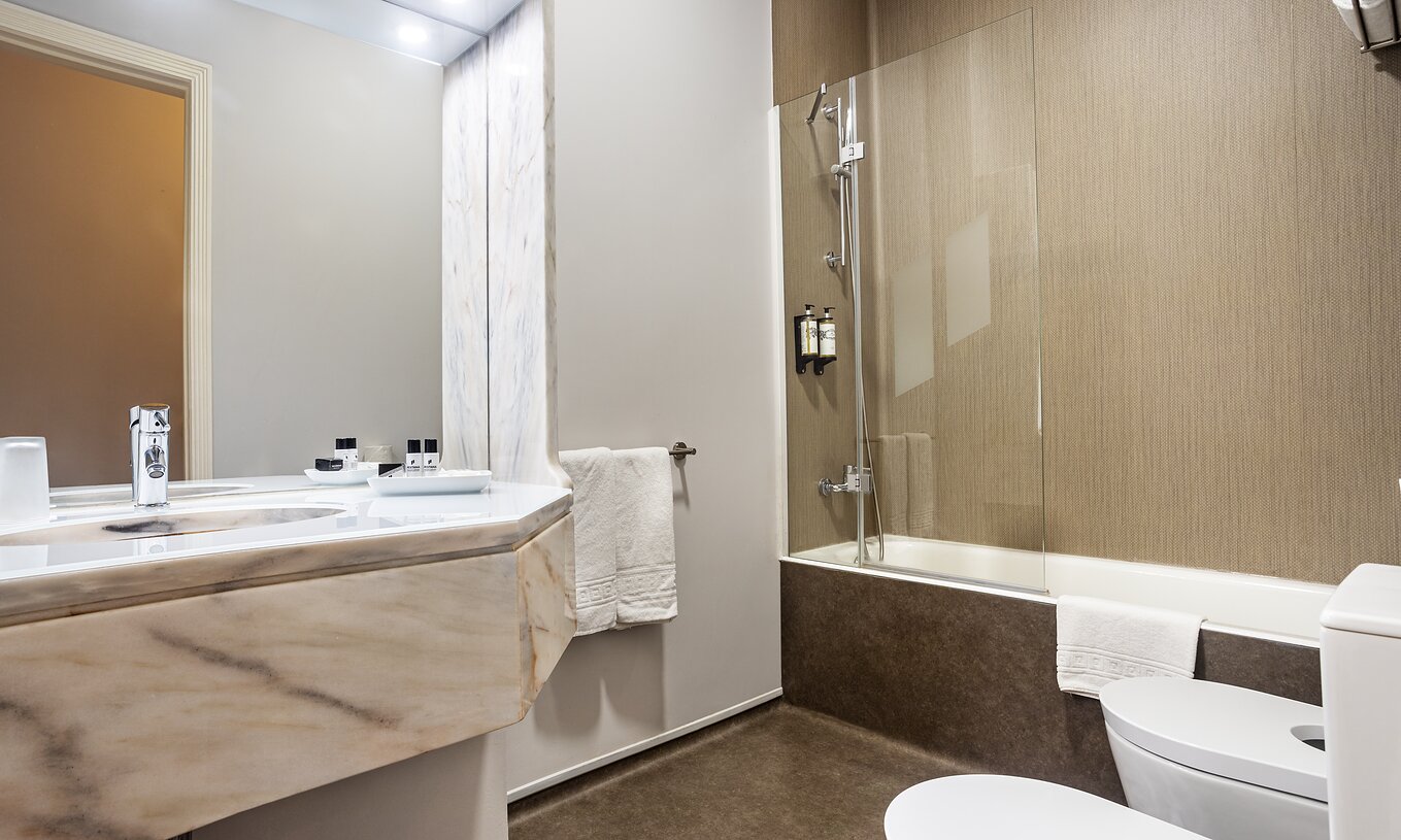 O Quarto Clássico da Pousada Ria - Aveiro conta com uma banheira com chuveiro, um lavatório e um espelho grande