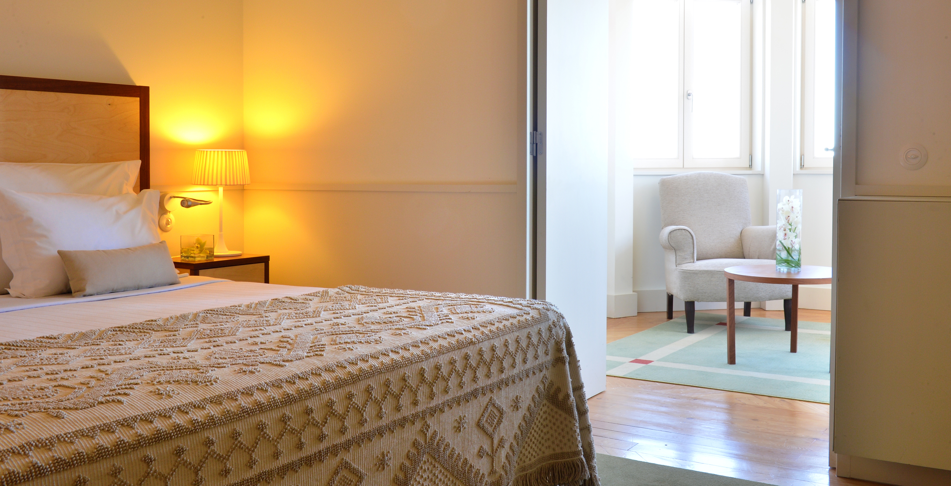 A Junior Suite da Pousada Serra da Estrela tem uma sala com uma poltrona e uma mesa de apoio, e duas janelas