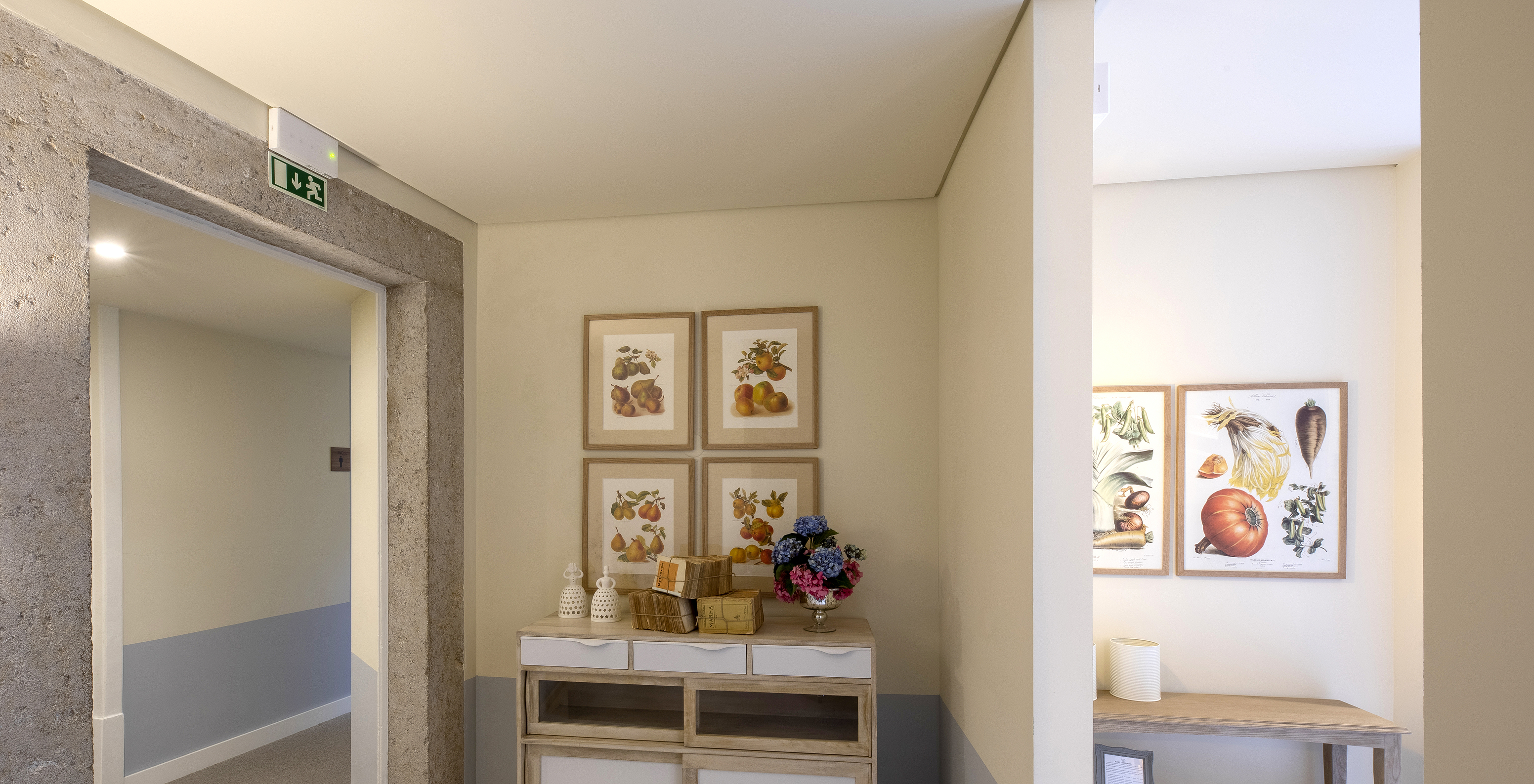 Corredor na Pousada Vila Óbidos, Bed and Breakfast em Óbidos com quadros com frutas como pêras e uma jarra de flores
