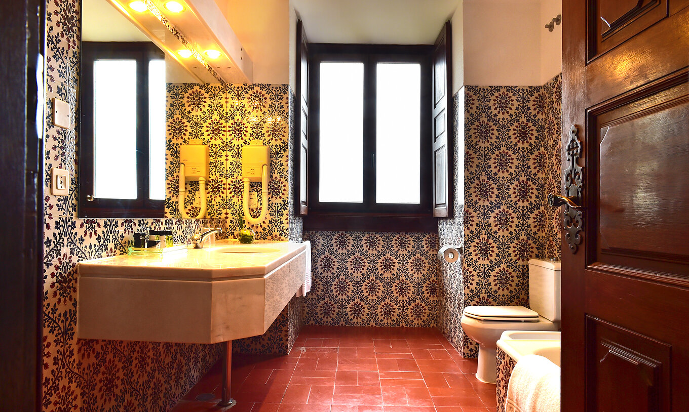 A Suite Standard da Pousada Castelo Palmela tem uma casa de banho com azulejos na parede, uma janela e lavatório com espelho