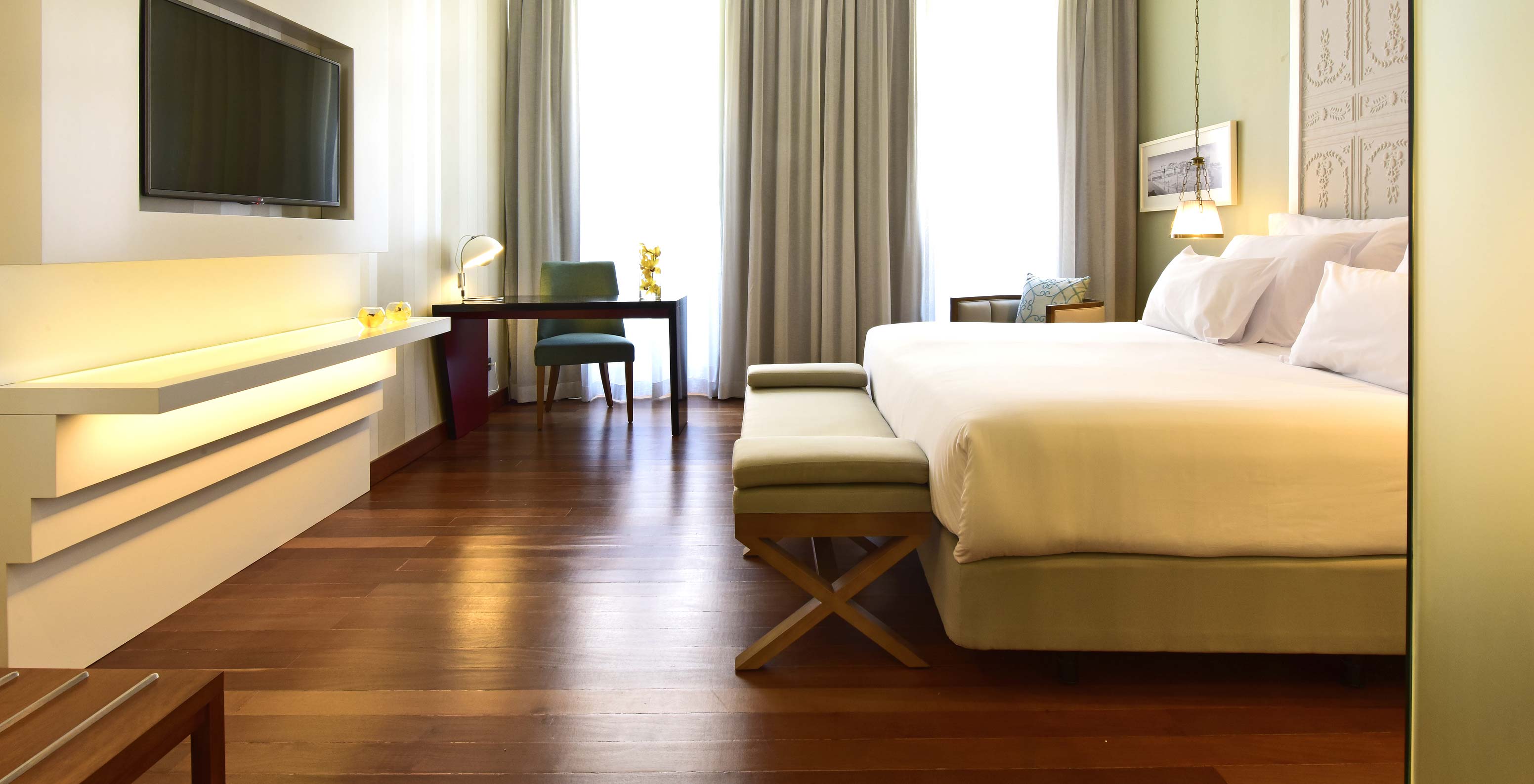 O Deluxe King Size Bed da Pousada de Lisboa Praça do Comércio tem cama de casal com baqueta ao fundo, secretária, janela e TV