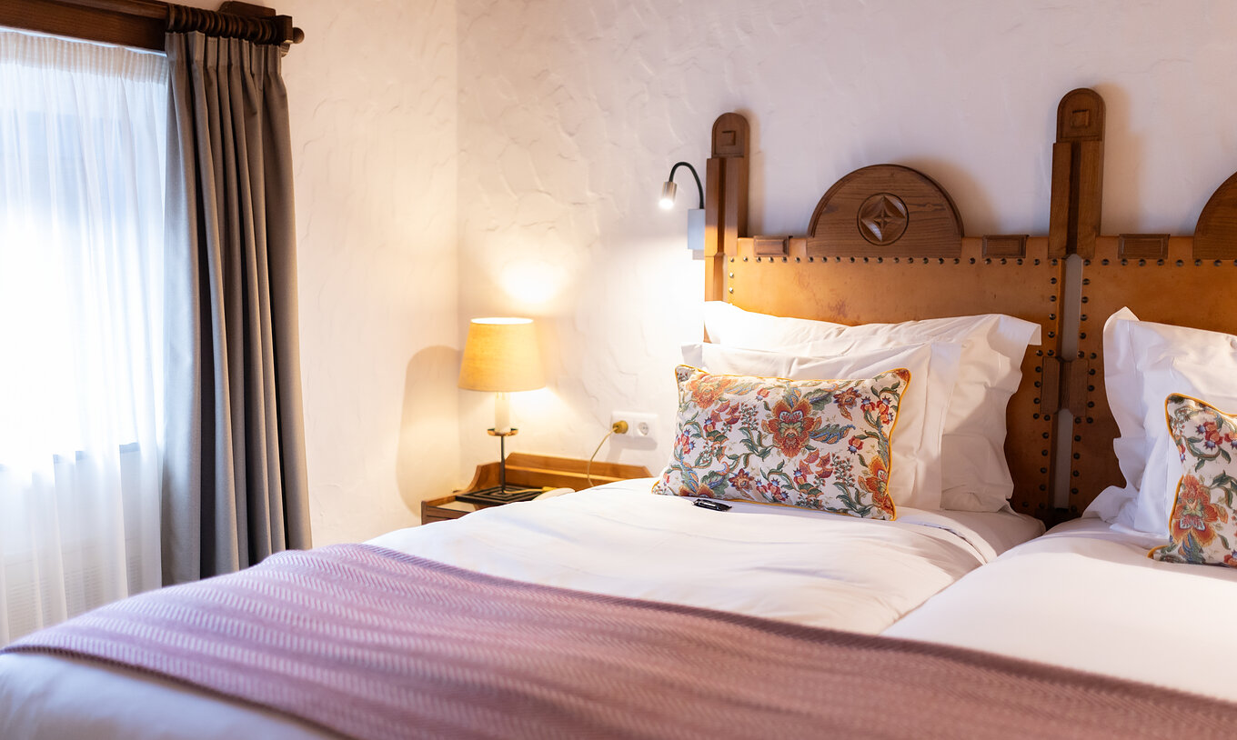 O Quarto Clássico da Pousada Caniçada - Gerês tem duas camas individuais com cabeceira em madeira e uma janela com cortinas