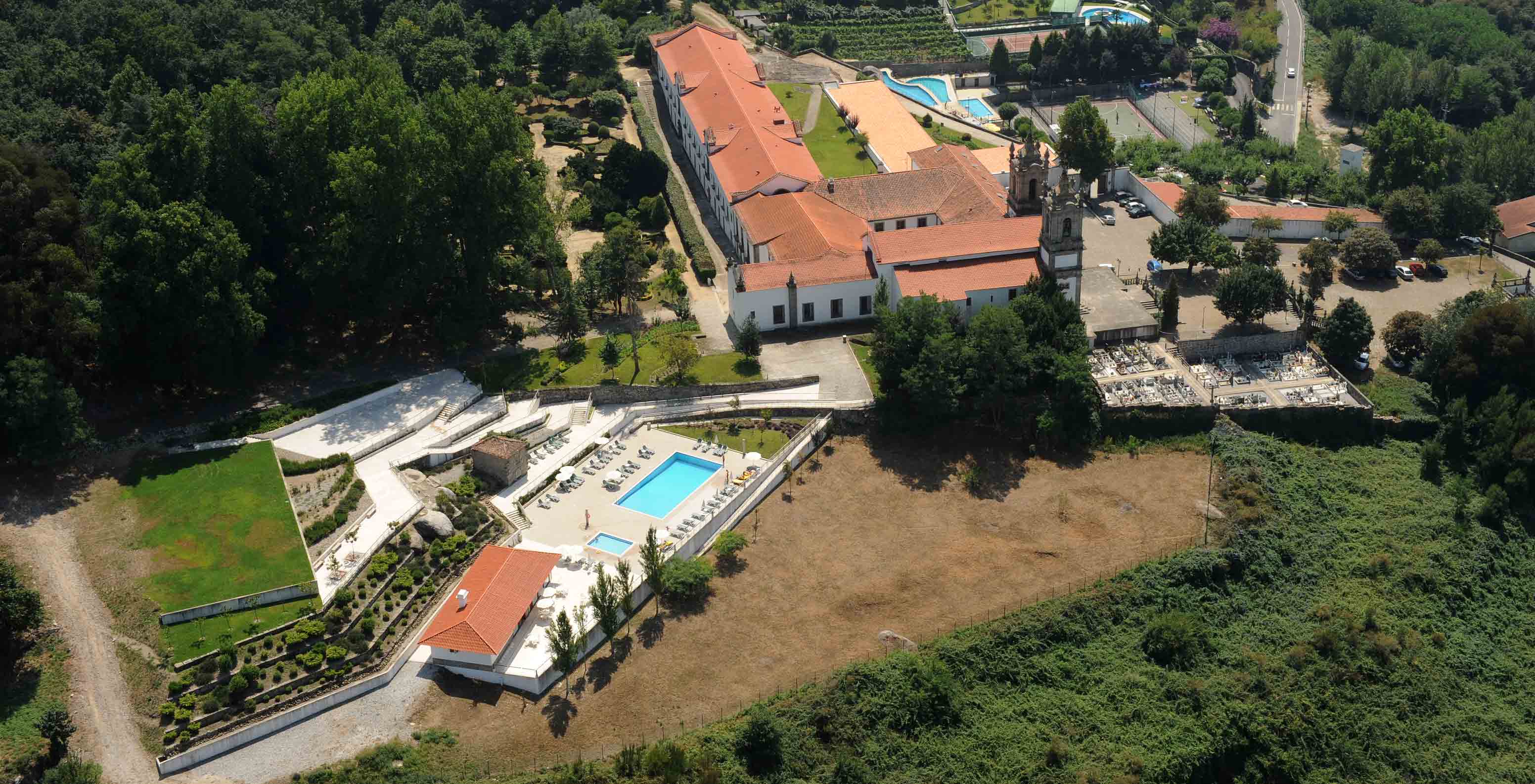 Vista aérea das piscinas da Pousada Mosteiro Guimarães, um hotel monumento onde pode relaxar e contactar com a natureza.