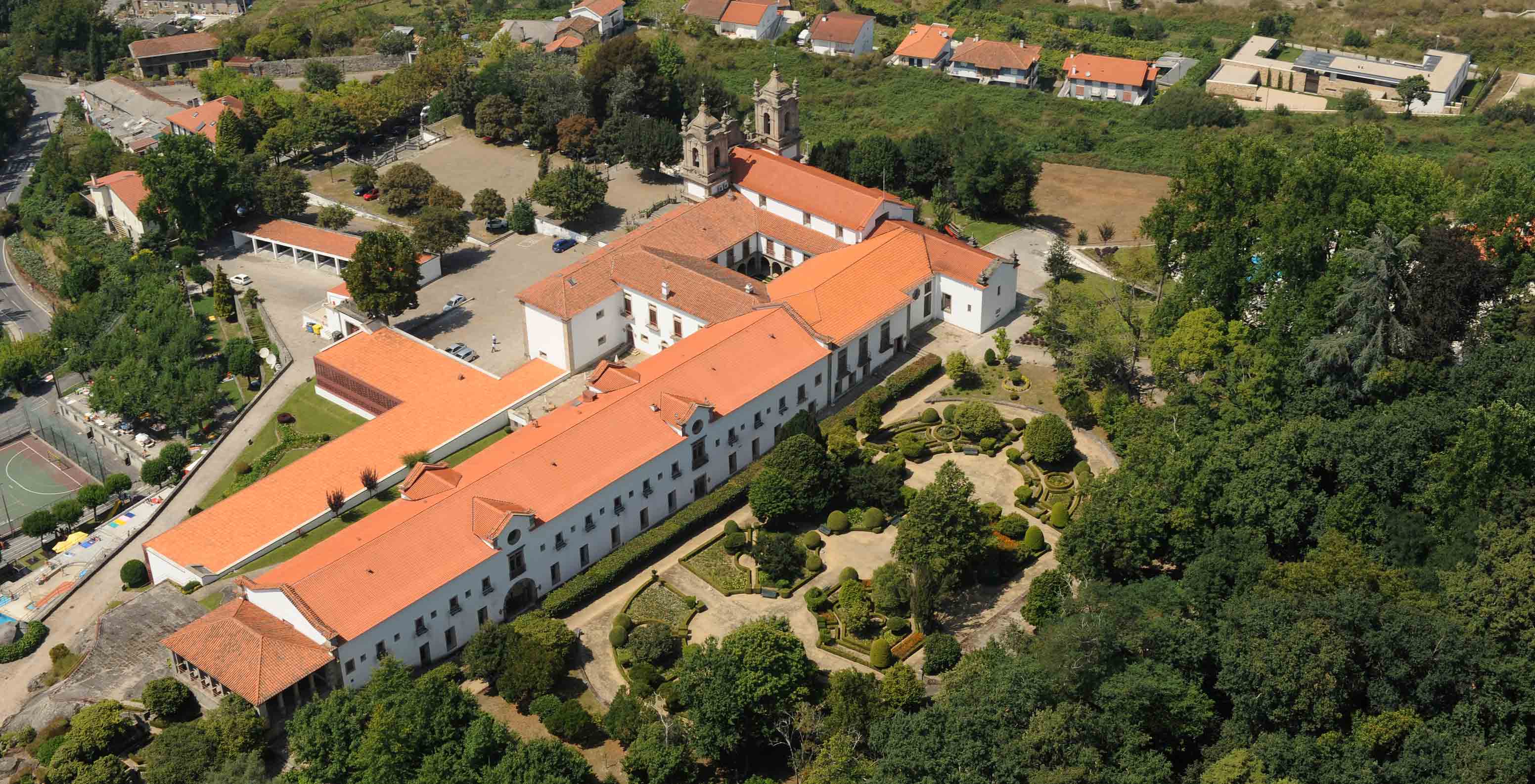Vista aérea exterior da fachada traseira da Pousada Mosteiro Guimarães, um hotel no centro histórico com jardim.