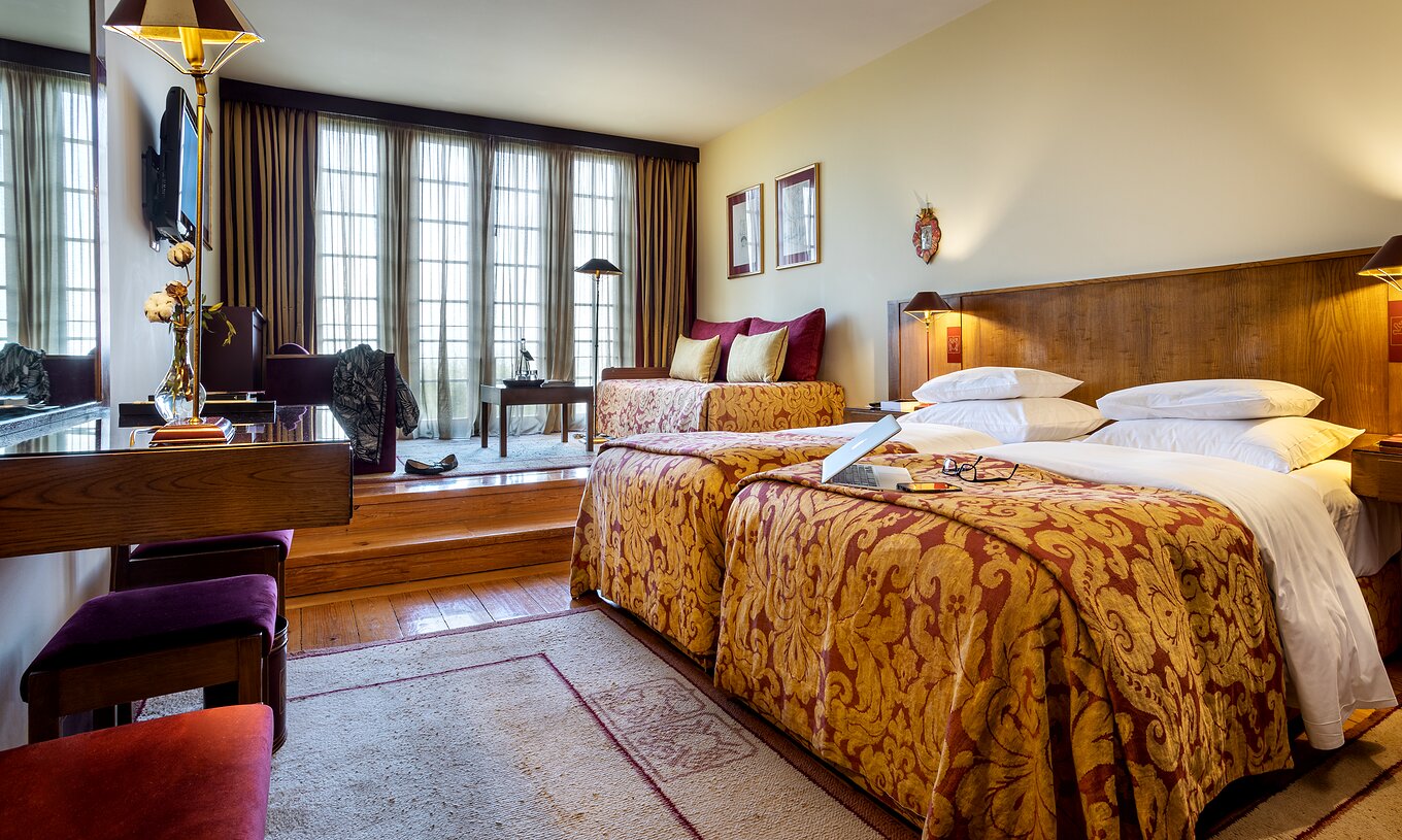 O Classic Family da Pousada Mosteiro Guimarães é um quarto amplo com duas camas grandes juntas, e dois sofás