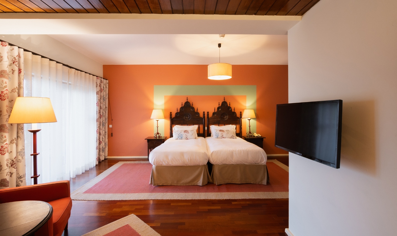 Quarto Superior com Terraço da Pousada Valença com duas camas individuais, candeeiros e decoração acolhedora
