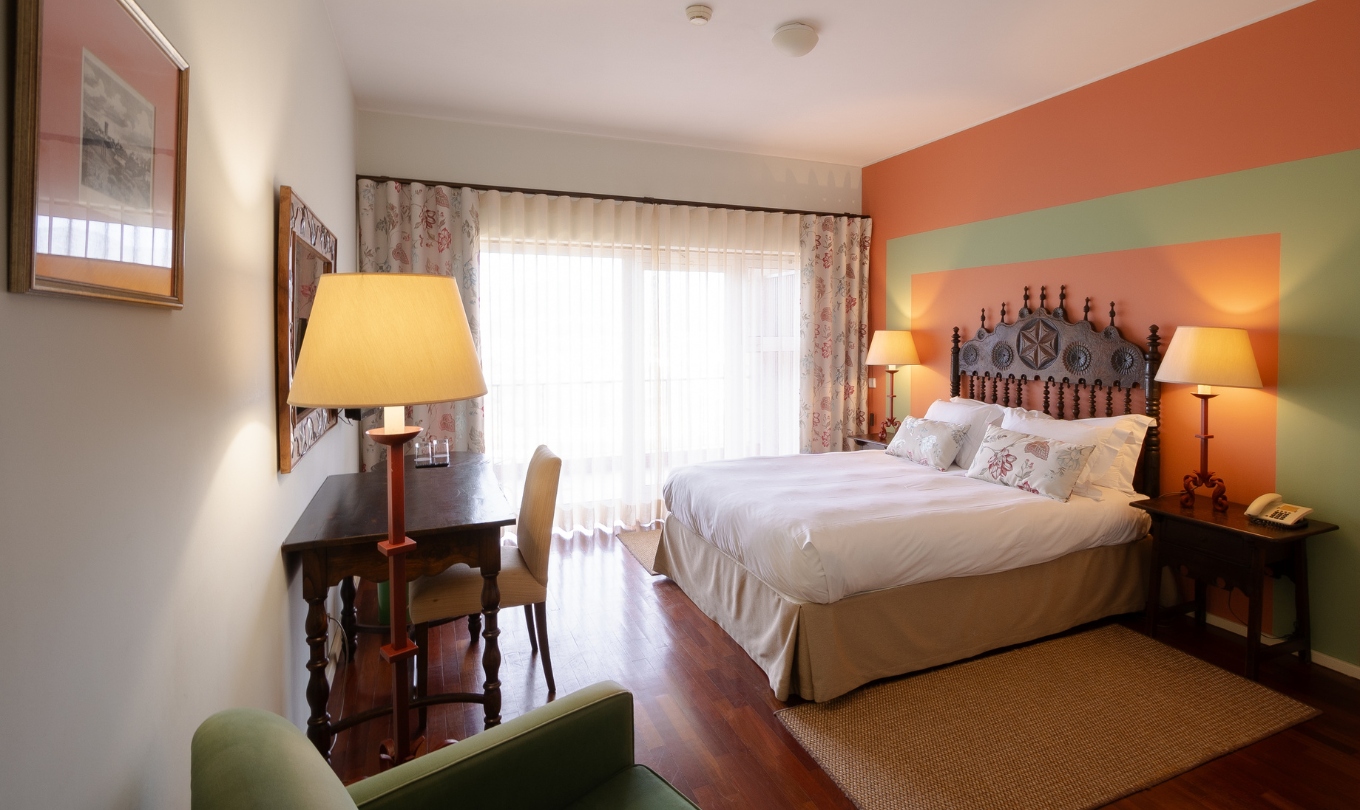 Quarto Superior com Terraço da Pousada Valença, com cama dupla, secretária e candeeiros junto à janela